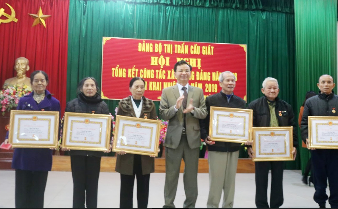 Đồng chí Hoàng Danh Lai-Bí thư Huyện ủy Quỳnh Lưu trao huy hiệu Đảng cho các đảng viên