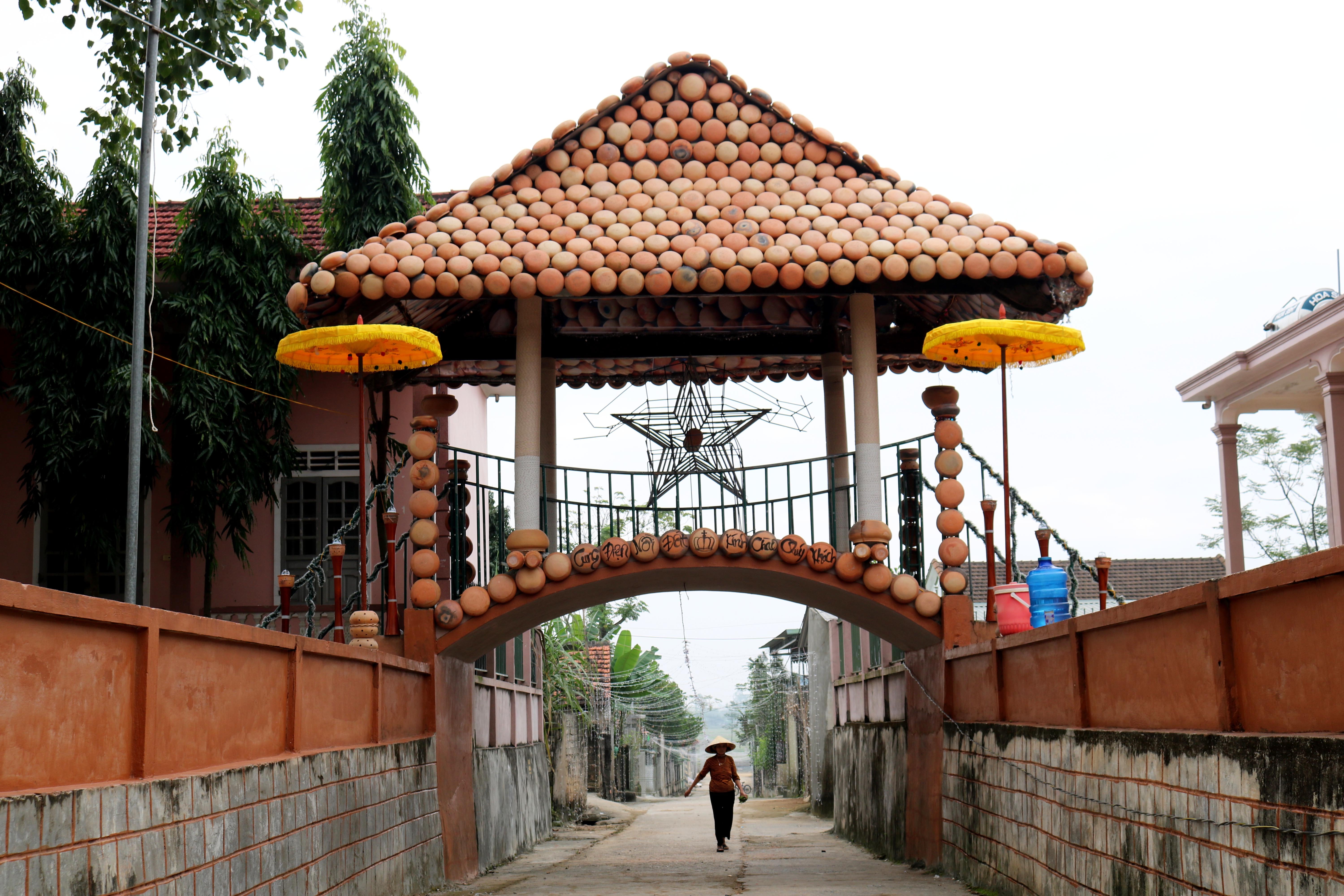 Ngoài cối xay gió khổng lồ, dịp này bà con giáo xứ Lưu Mỹ còn dựng “cung điện nồi đất” là ngôi nhà một gian bắc qua đường xóm. ảnh: Huy Thư