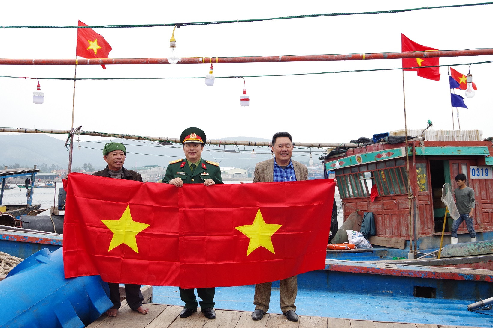 Đại tá Vương Kim Hải trong một lần trao tặng cờ tổ quốc cho ngư dân. Ảnh: Phong Quang