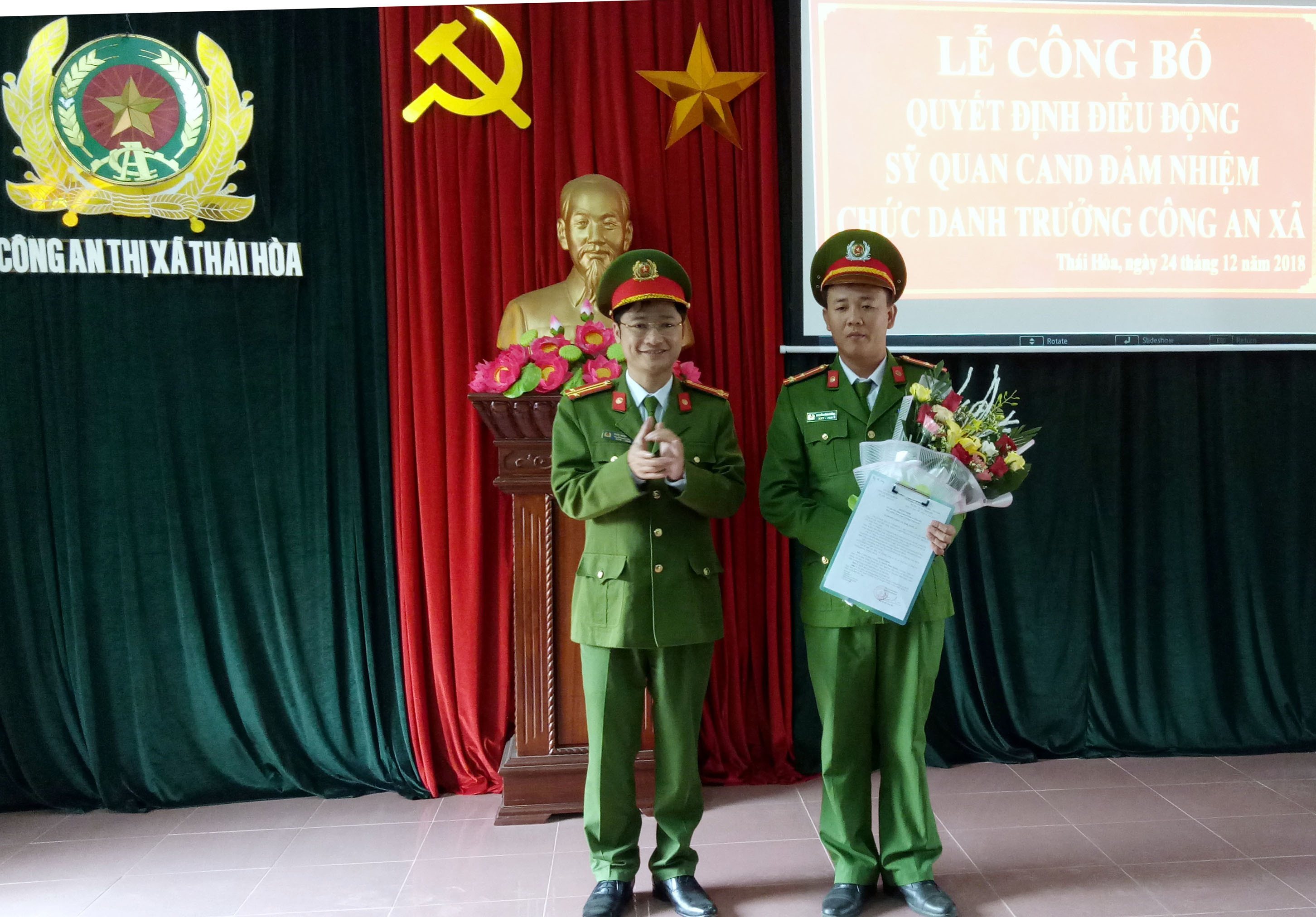 Trung tá Trần Ngọc Tuấn - Trưởng Công an thị xã Thái Hòa trao Quyết định và tặng hoa chúc mừng tân Trưởng Công an xã Nghĩa Hòa. Ảnh: Quang Huy