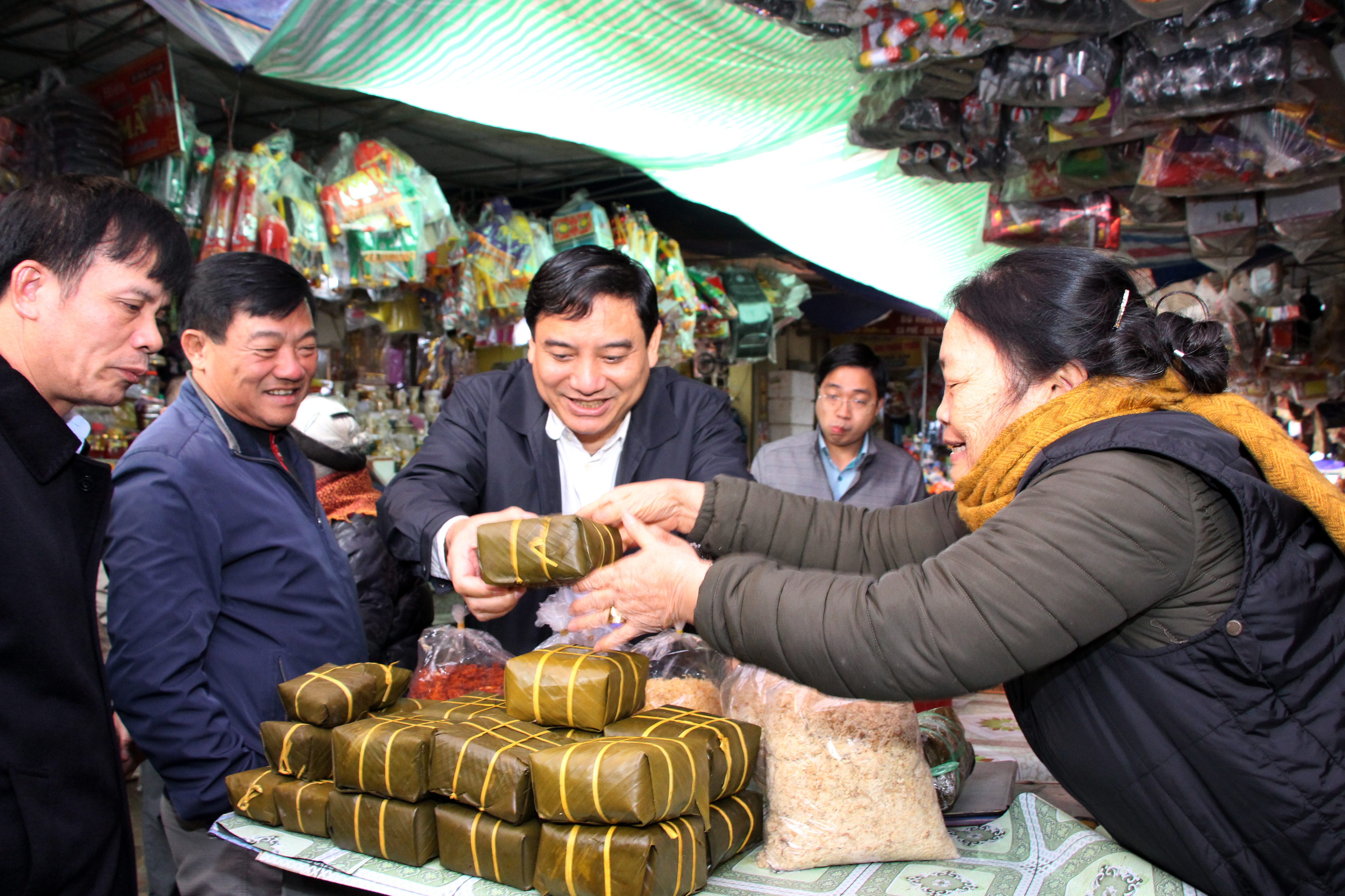 Bí thư Tỉnh ủy Nguyễn Đắc Vinh mua cặp bánh chưng động viên hộ kinh doanh tại chợ Vinh. Ảnh: Đào Tuấn 
