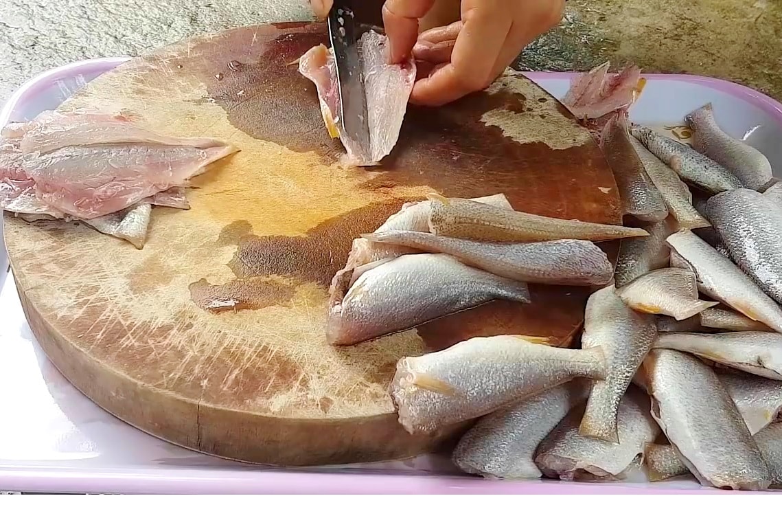 Với bà con làng biển Quỳnh Nghĩa, món cá đù là đặc sản “hút khách” ngày Tết. Cá đù được khai thác từ những còn thuyền gần bờ; sau khi thu mua, người dân rửa sạch bỏ phần đầu, ruột rồi xẻ làm đôi. Sau đó, cá sẽ được ướp các loại gia vị như: đường, ớt cay, tương xay nhuyễn; tùy vào nhu cầu người mua, cá có thể phơi “một nắng” hoặc  3 - 4 nắng mới đóng gói. Ảnh: Việt Hùng