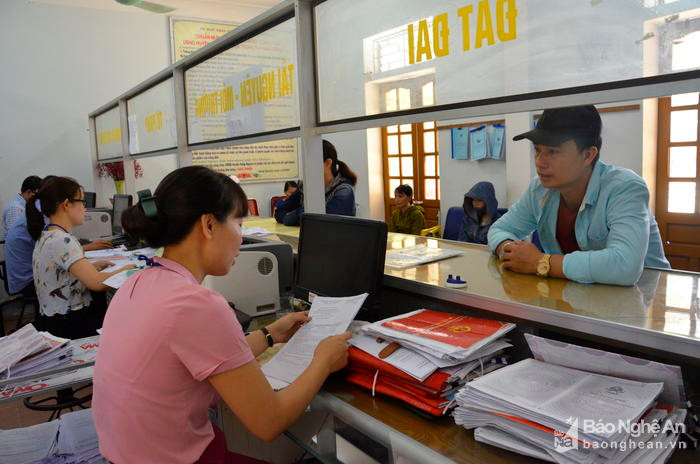 Giải quyết TTHC cho người dân tại Bộ phận một cửa UBND huyện Hưng Nguyên. Ảnh: Lê Thanh
