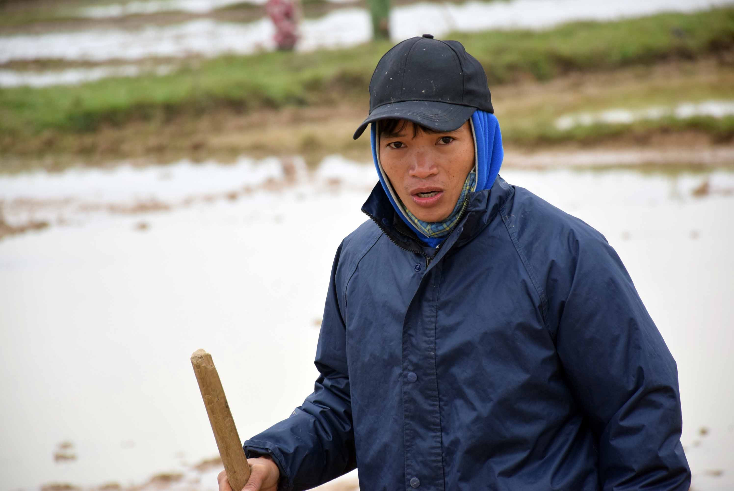 Lão nông Nguyễn Văn Hà.... co ro trong gió rét ngoài đồng. Ảnh: Xuân Hoàng