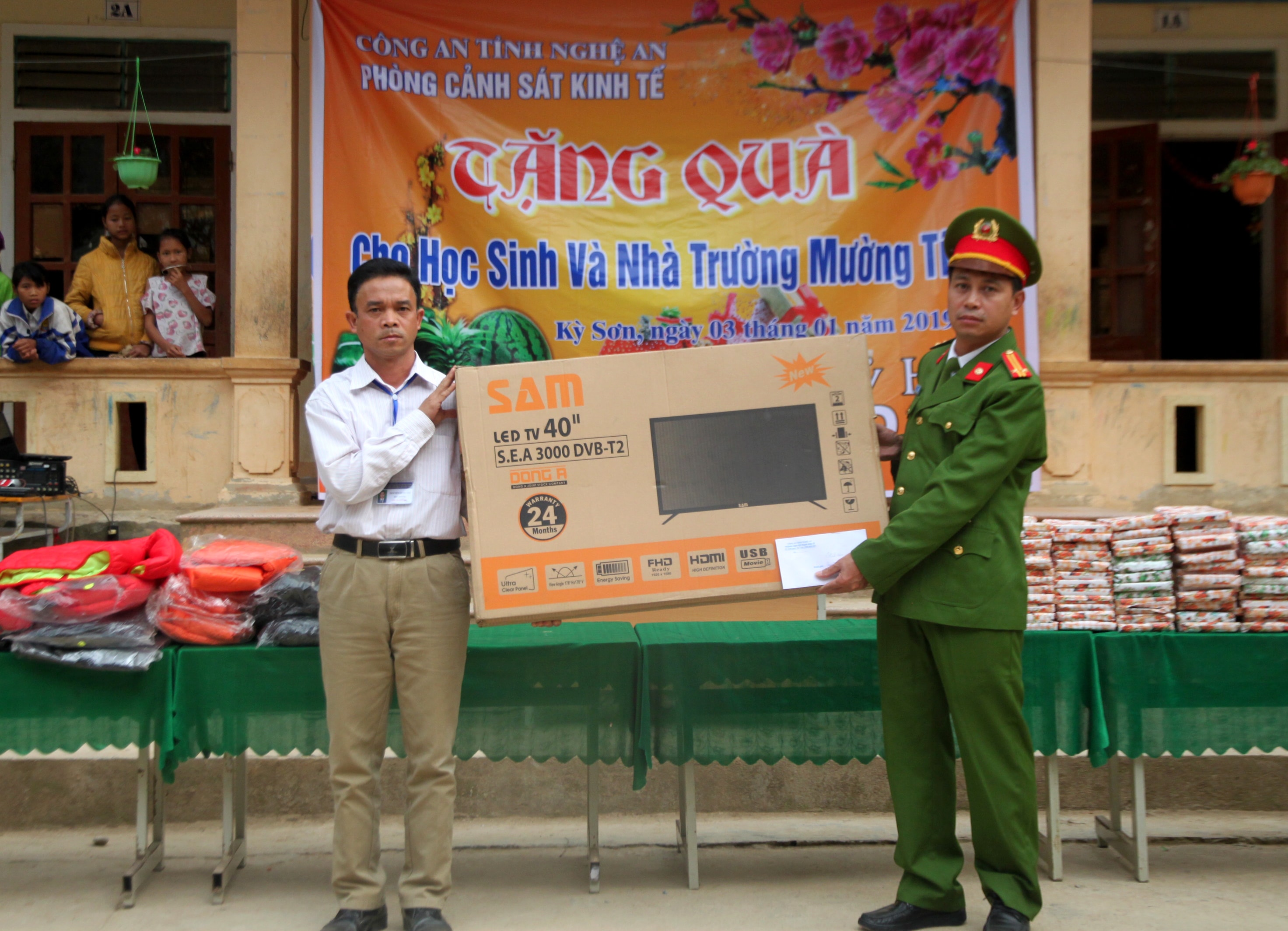 Trung tá Nguyễn Xuân Thái - Phó trưởng phòng Cảnh sát Kinh tế trao tặng tiền mặt 5 triệu đồng và 01 chiếc tivi cho nhà trường. Ảnh: Đức Vũ