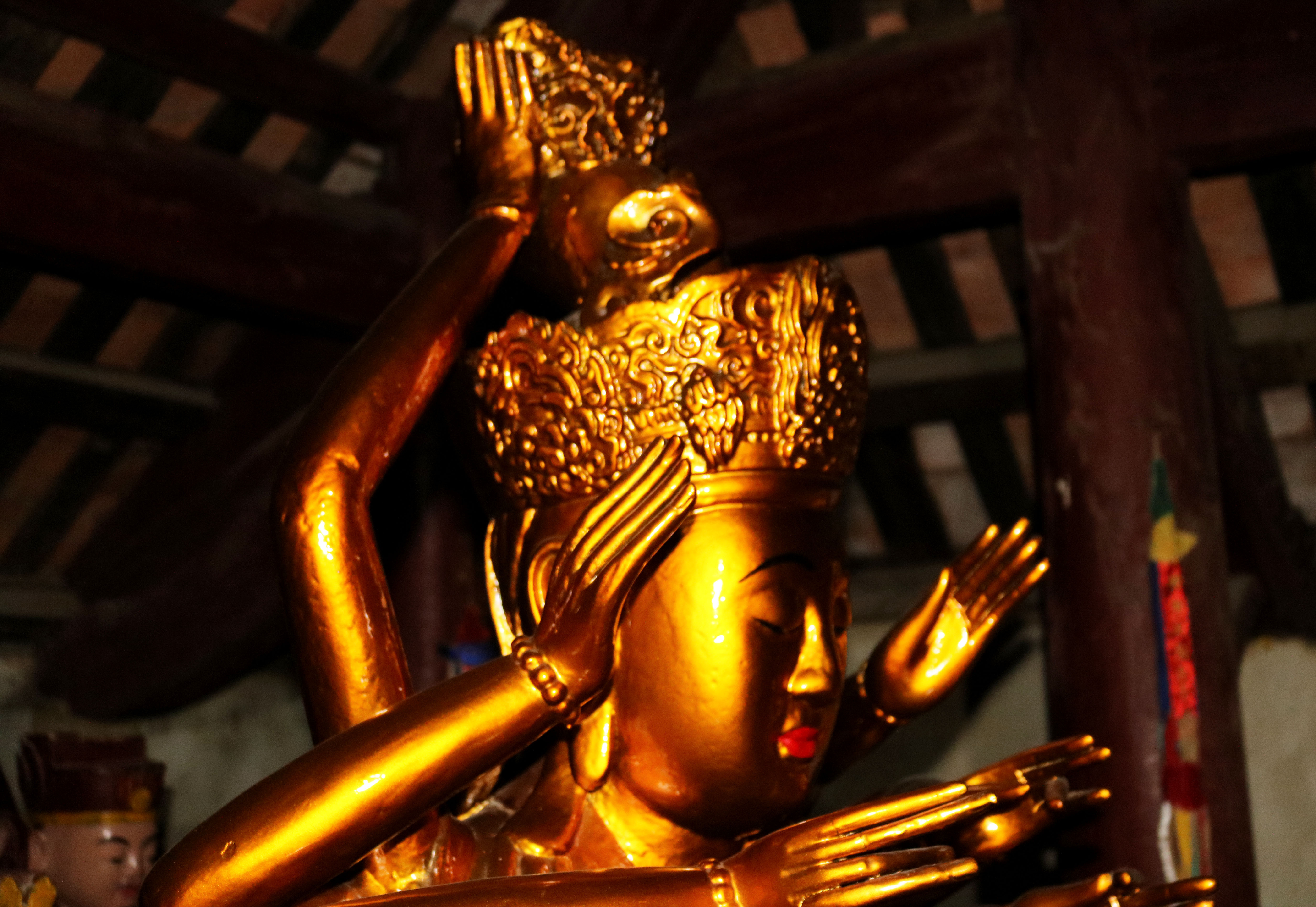 Phần trên của tượng Phật Mẫu Chuẩn Đề với khuôn mặt nhân từ, hai tay đang nâng mũ hoa. Ảnh: Huy Thư