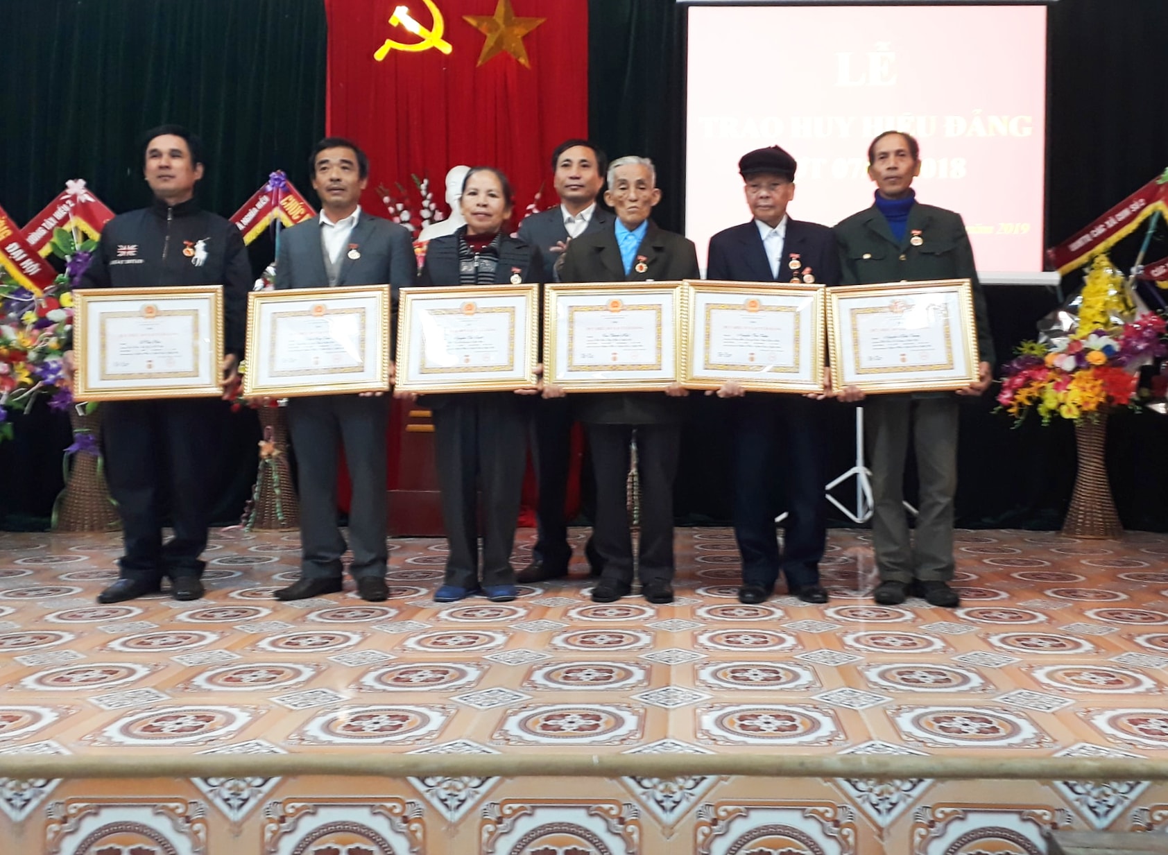 Trao tặng huy hiệu đảng co các đảng viên. Ảnh: Minh Thái 