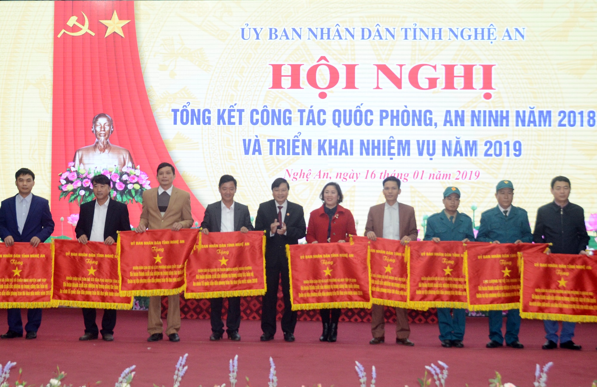 Trao tặng cờ thi đua dẫn đầu cho 16 tập thể có thành tích xuất sắc trong công tác quốc phòng, an ninh năm 2018. Ảnh: Thành Chung