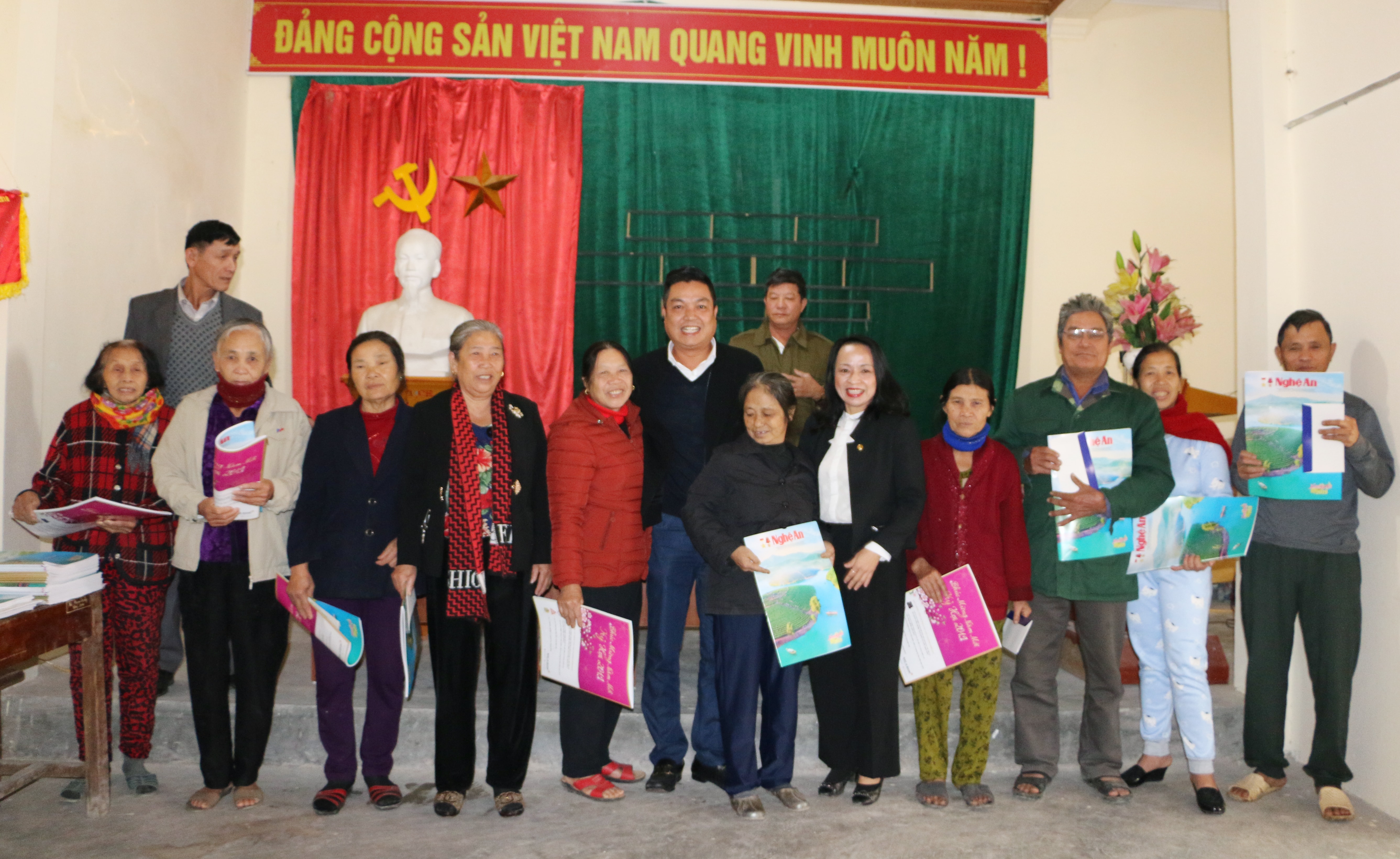 Đoàn công tác tặng quà và chụp ảnh với các hộ nghèo, gia đình chính sách tại xóm Phúc Điền 1, xã Hưng Tây, Hưng Nguyên. Ảnh: Nguyễn Hải
