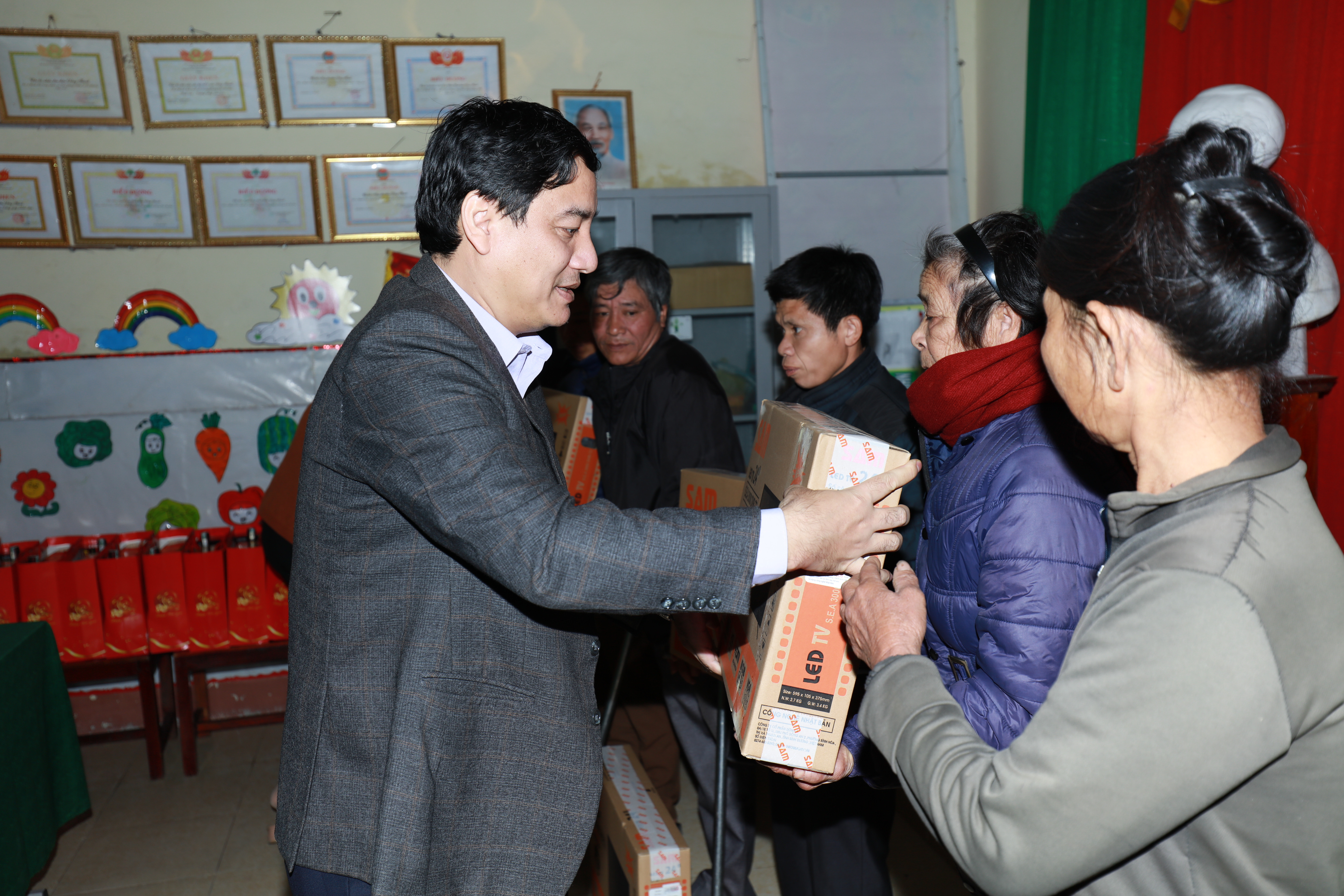Bí thư Tỉnh ủy Nguyễn Đắc Vinh trao quà cho các hộ nghèo thị xã Hoàng Mai. Ảnh: Lê Tuấn Anh