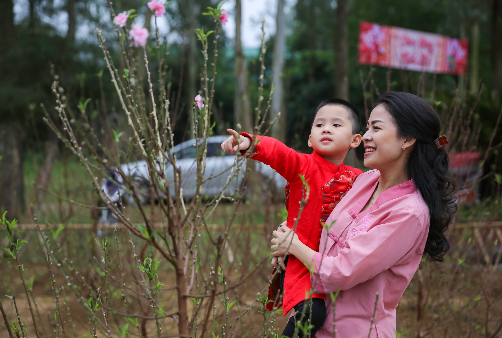 Những em nhỏ tỏ ra thích thú khi được ngắm những bông hoa đào nở sớm. Ảnh Đức Anh