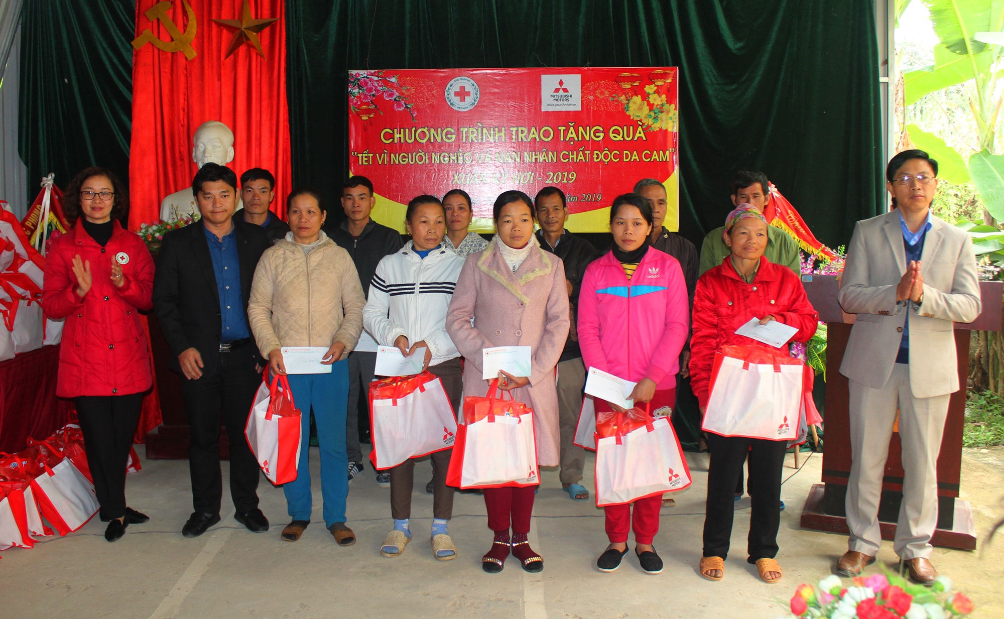 Đoàn công tác và đại diện nhà tài trợ chụp ảnh lưu niệm với các hộ nghèo sau khi trao quà Tết. Ảnh: Nguyễn Hải