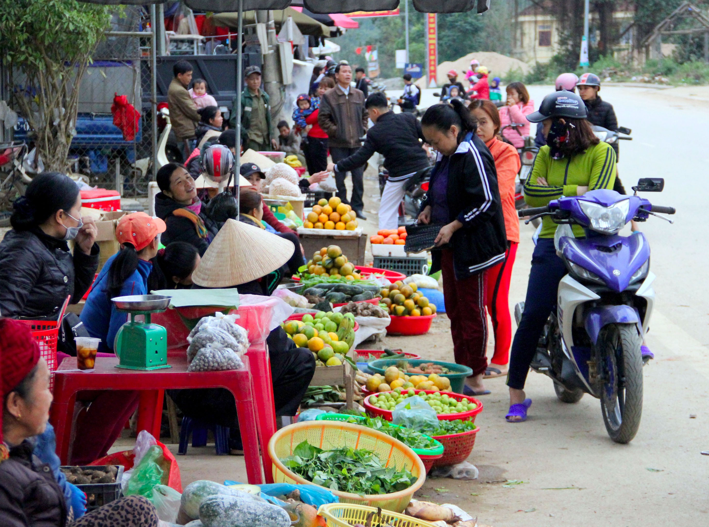 Người dân vô tư mua bán hai bên đường Quốc lộ 7, đoạn trước cổng chợ Tân Lạc, mặc dù trước đó mấy tháng, chính quyền địa phương đã quyết liệt đẩy đuổi mọi người vào chợ Tân Lạc buôn bán hàng hóa. Ảnh: Xuân Hoàng