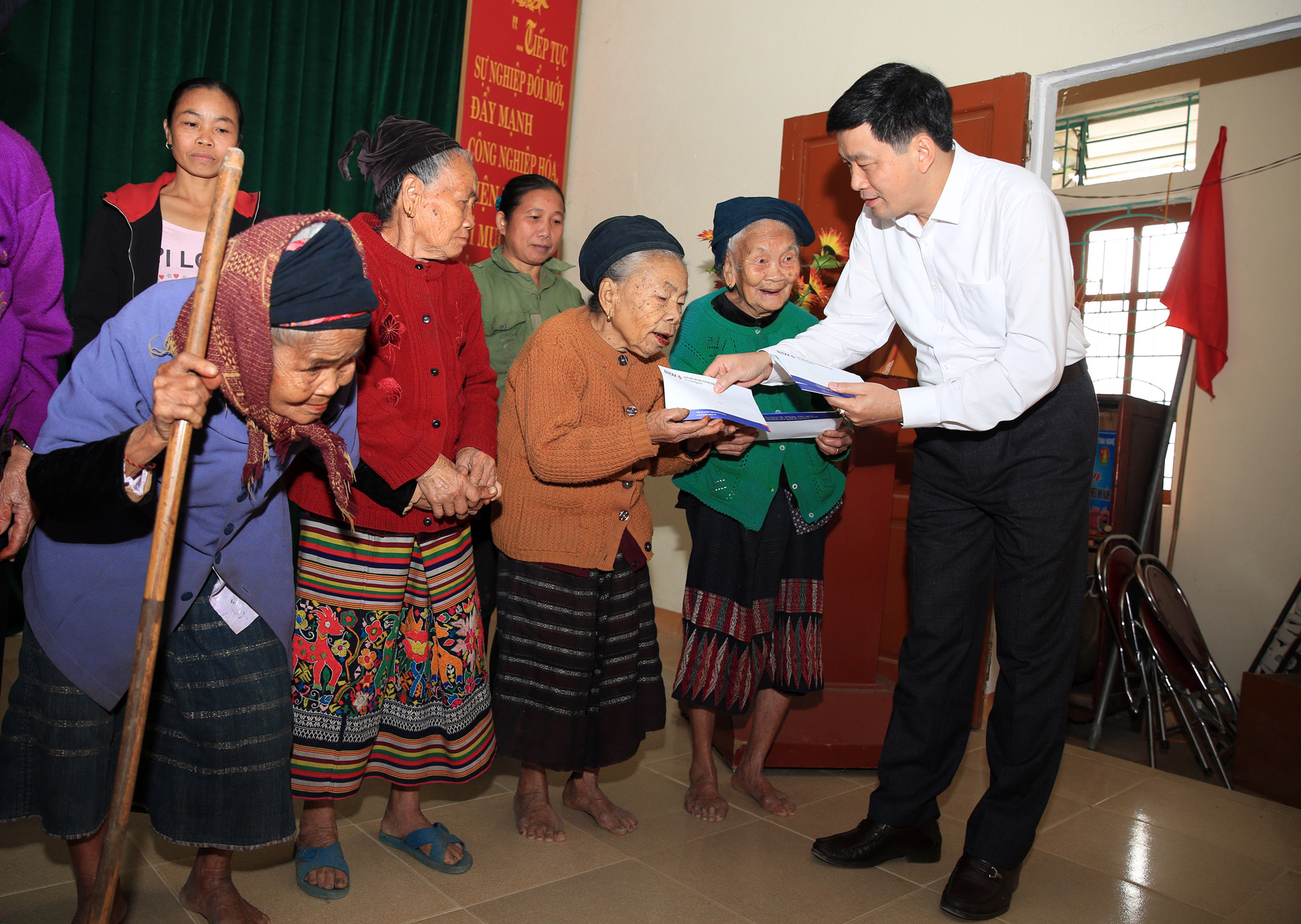 Ông Kha Văn Tám, trao quà tại xã Tam Đình, huyện Tương Dương cho người dân ăn tết. Ảnh: Hồ Phương