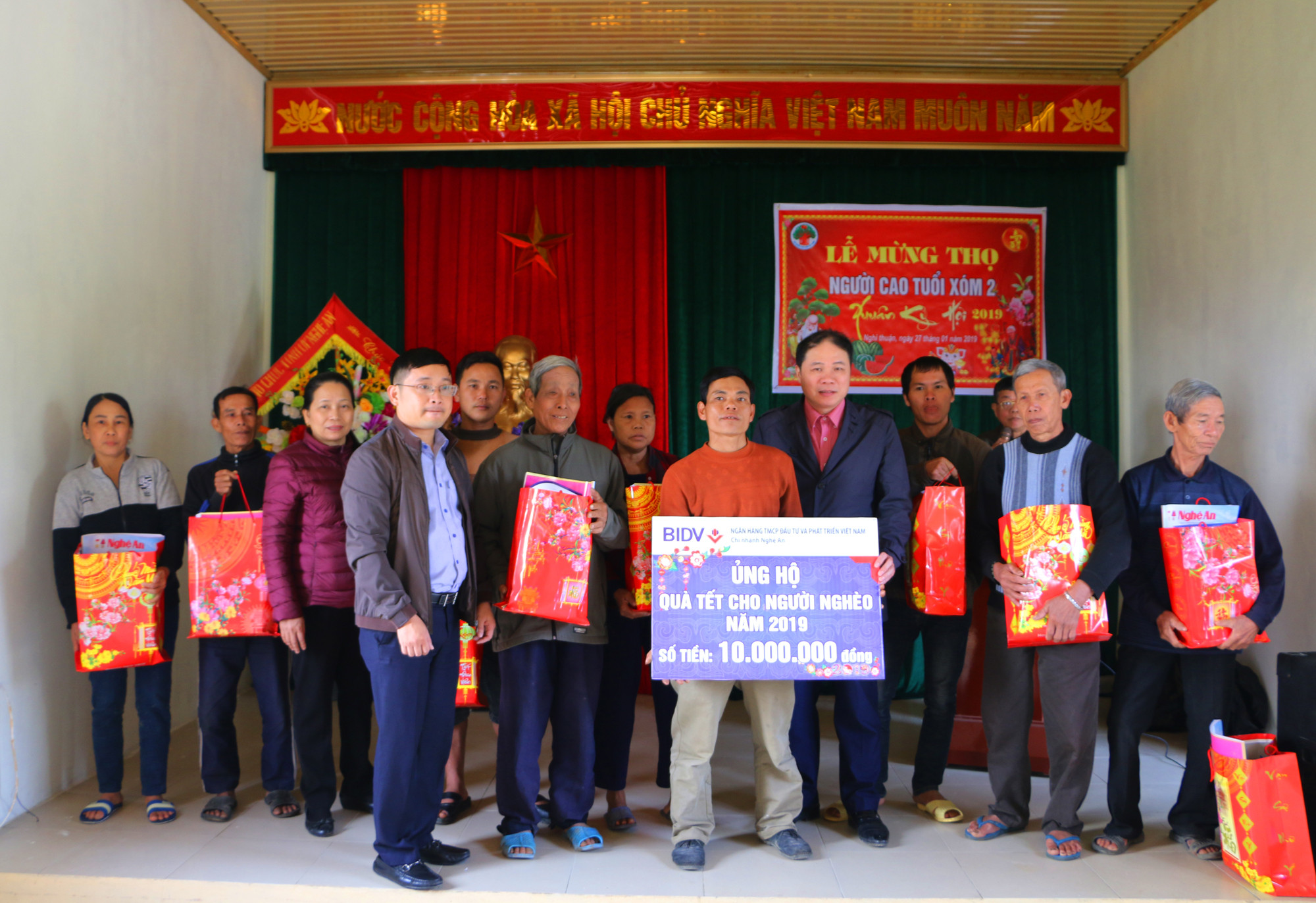 Đại diện Ban Tổ chức Tỉnh ủy và nhà tài trợ BIDV Nghệ An trao 10 suất quà Tết cho hộ nghèo xóm 2. Ảnh: Nguyễn Hải