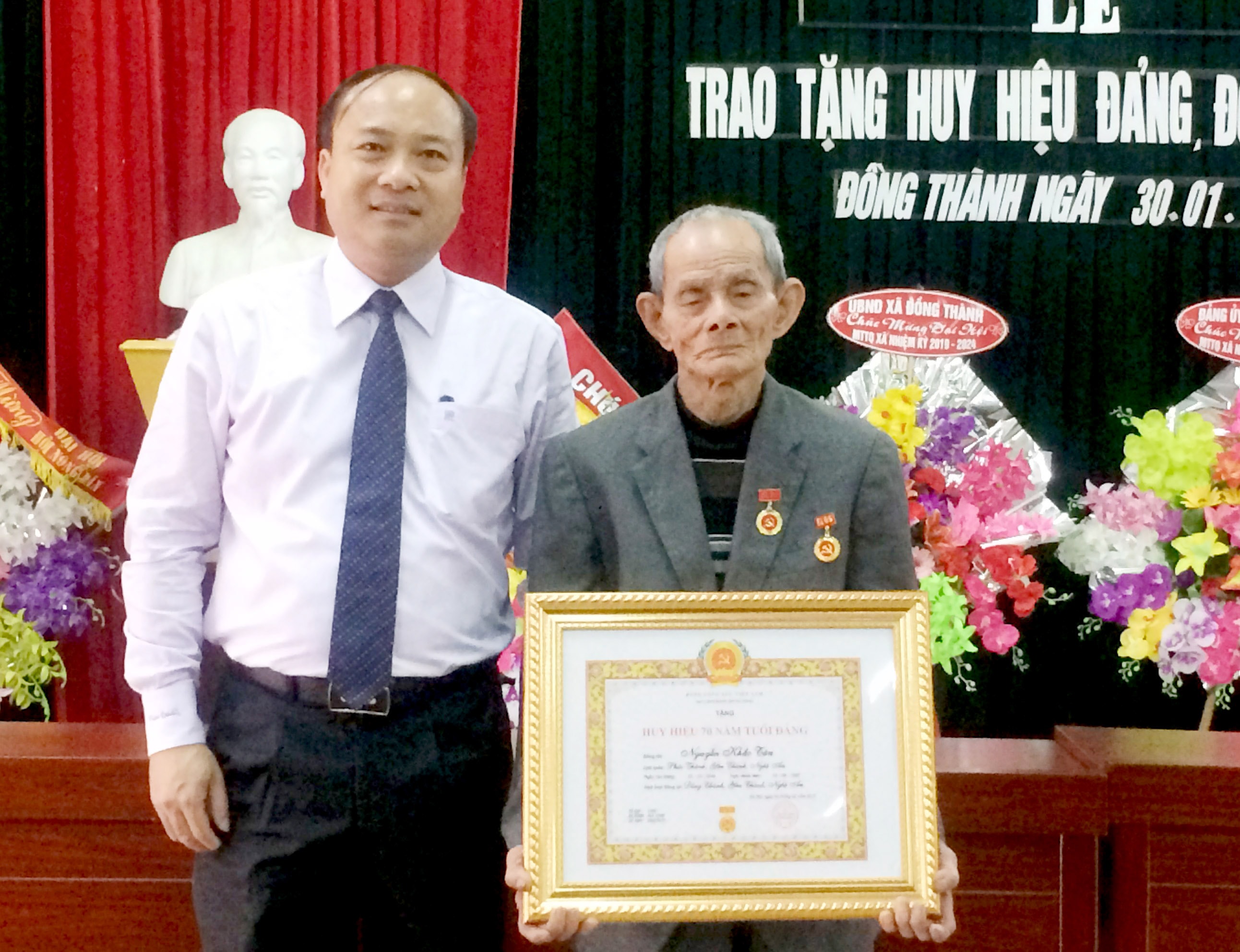 Phó Bí thư Thường trực Huyện ủy Yên Thành Nguyễn Viết Hưng trao Huy hiệu 70 năm tuổi Đảng cho đảng viên Nguyễn Khắc Tân. Ảnh: