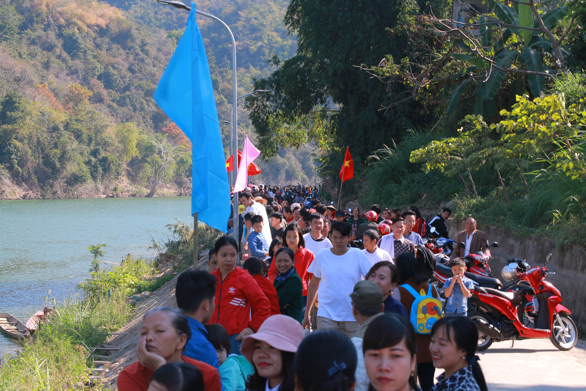 Hàng nghìn người tập trung bên bờ sông Lam để xem lễ hội đua thuyền. Ảnh: Đình Tuân