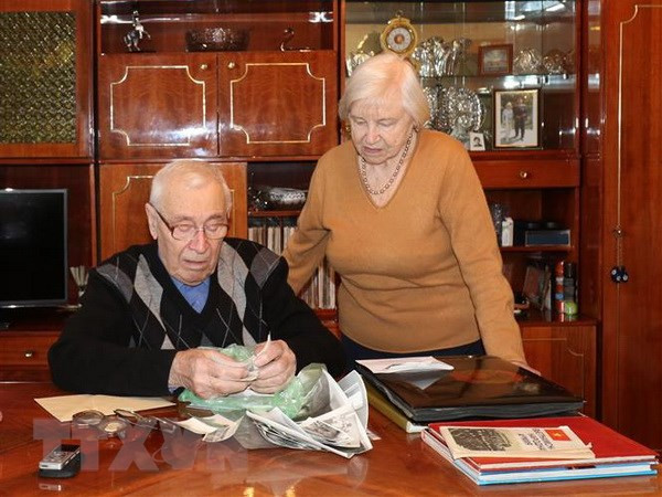Ông bà Ivashko bùi ngùi xem lại từng bức ảnh đã lưu giữ gần 40 năm qua. Ảnh: Hồng Quân/TTXVN