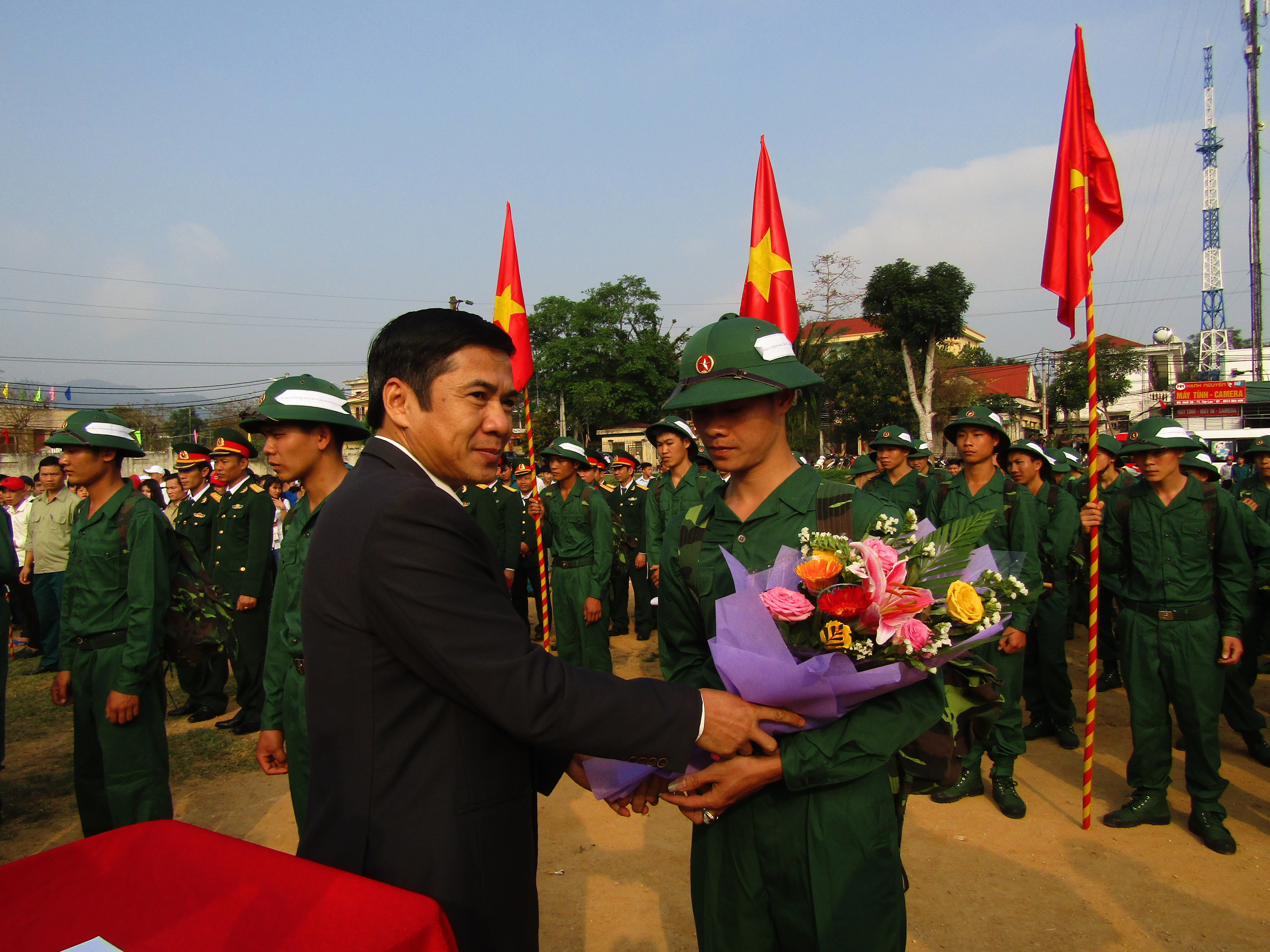 Lãnh đạo huyện tặng hoa và quà cho các tân binh trước lúc lên đường nhận nhiệm vụ. Ảnh: Bé Vinh