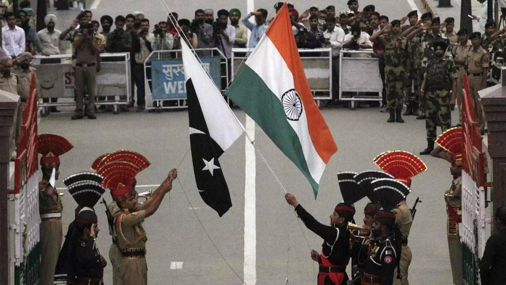 Binh lính Pakistan (đồng phục đen) và lính biên phòng Ấn Độ trong buổi lễ chào cờ hằng ngày ở biên giới. Ảnh: Reuters