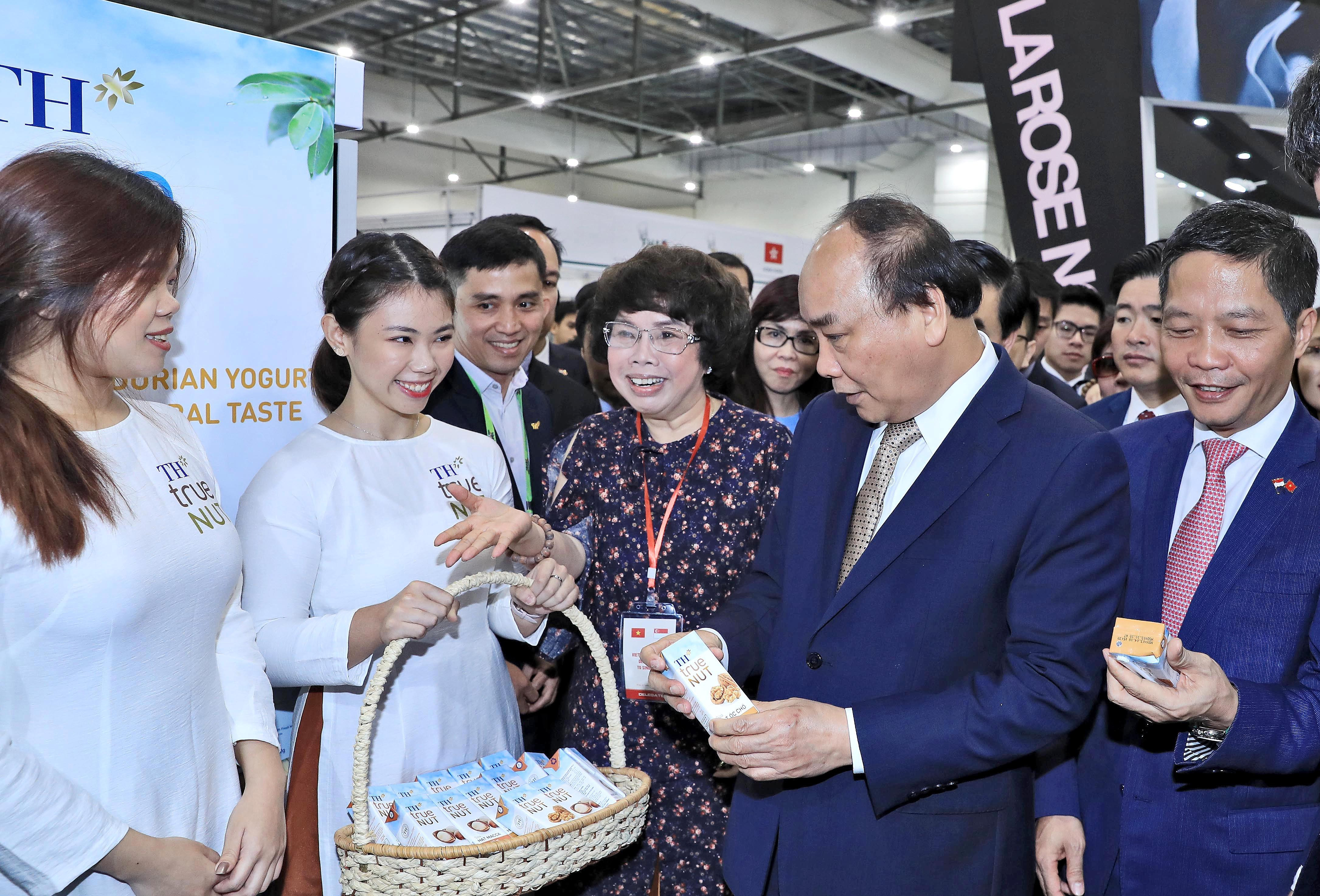 Thủ tướng Nguyễn Xuân Phúc nghe giới thiệu về sản phẩm của Tập đoàn TH. Ảnh: P.V