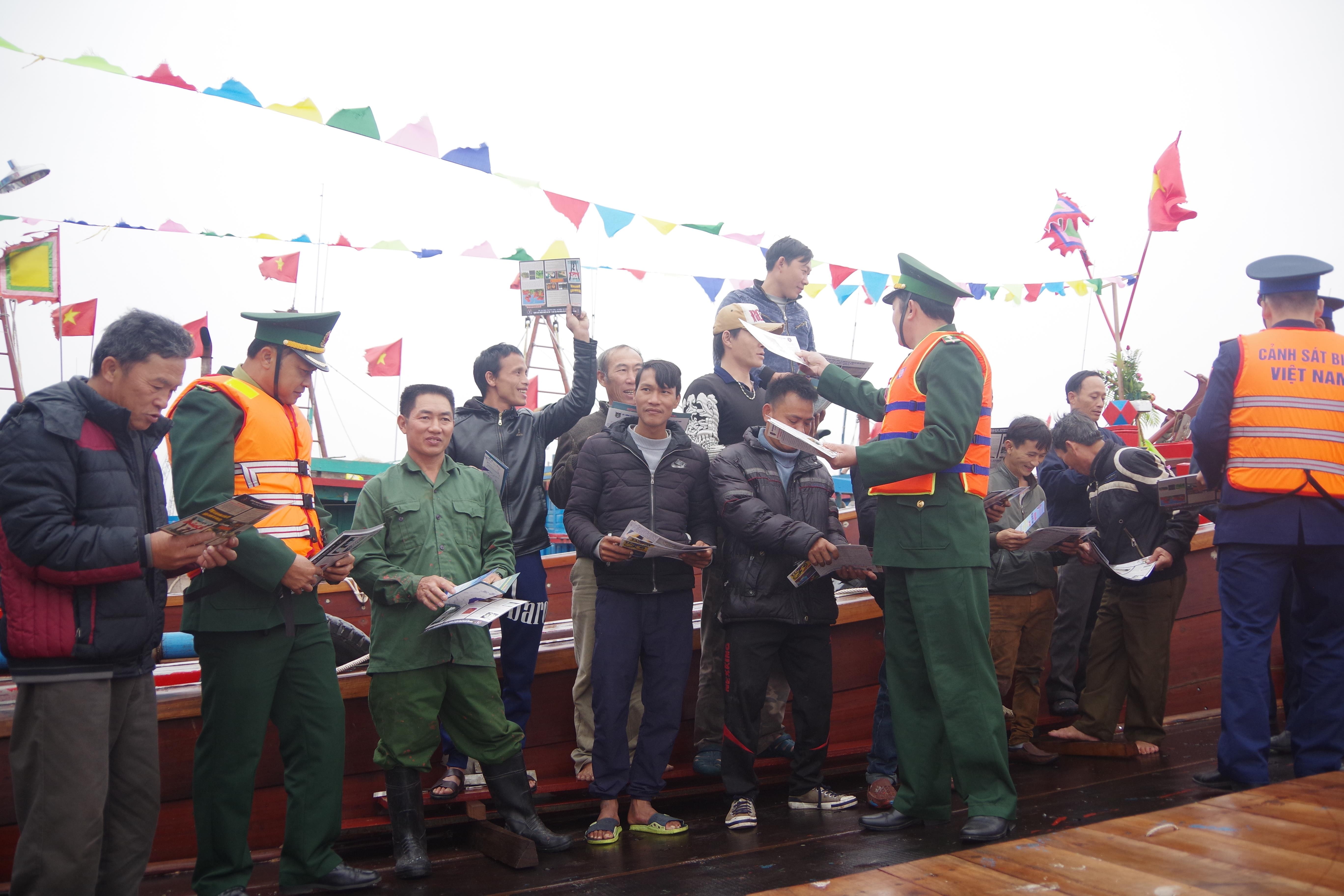 Phát tờ rơi, tuyên truyền pháp luật cho ngư dân. Ảnh: Nhật Tuấn