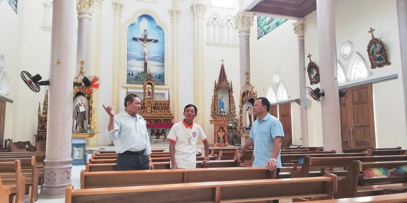 Ông Lâm (bên trái) chia sẻ kinh nghiệm đoàn kết lương giáo với lãnh đạo xã tại nhà thờ giáo họ Đông Khê. Ảnh: Mai Giang