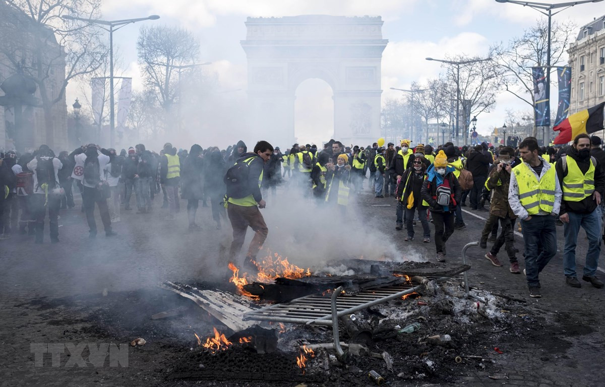 Người biểu tình Áo vàng đốt các rào chắn trên đại lộ Champs-Elysees ở Paris, Pháp, ngày 16/3. (Nguồn: THX/TTXVN)