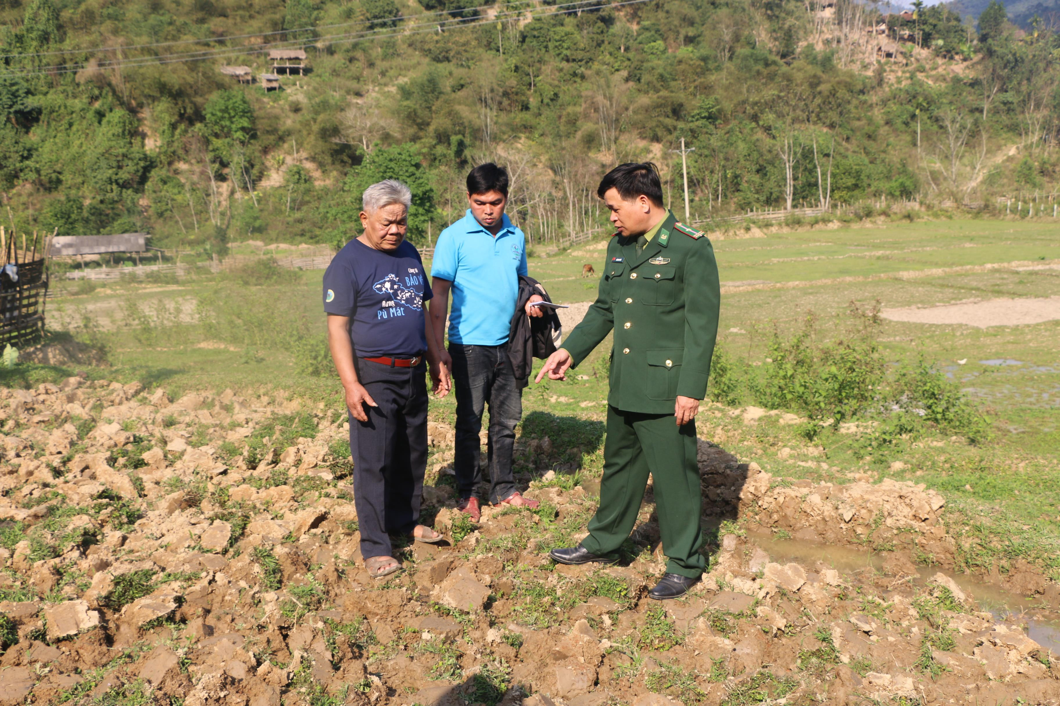 già làng Lô Xuân Tiến ( ngoài cùng bên trái) trao đổi với trưởng bản Liên Hương và cán bộ Đồn biên phòng Tam Quang về tình hình sản xuất của người dân. Ảnh: Gia Huy