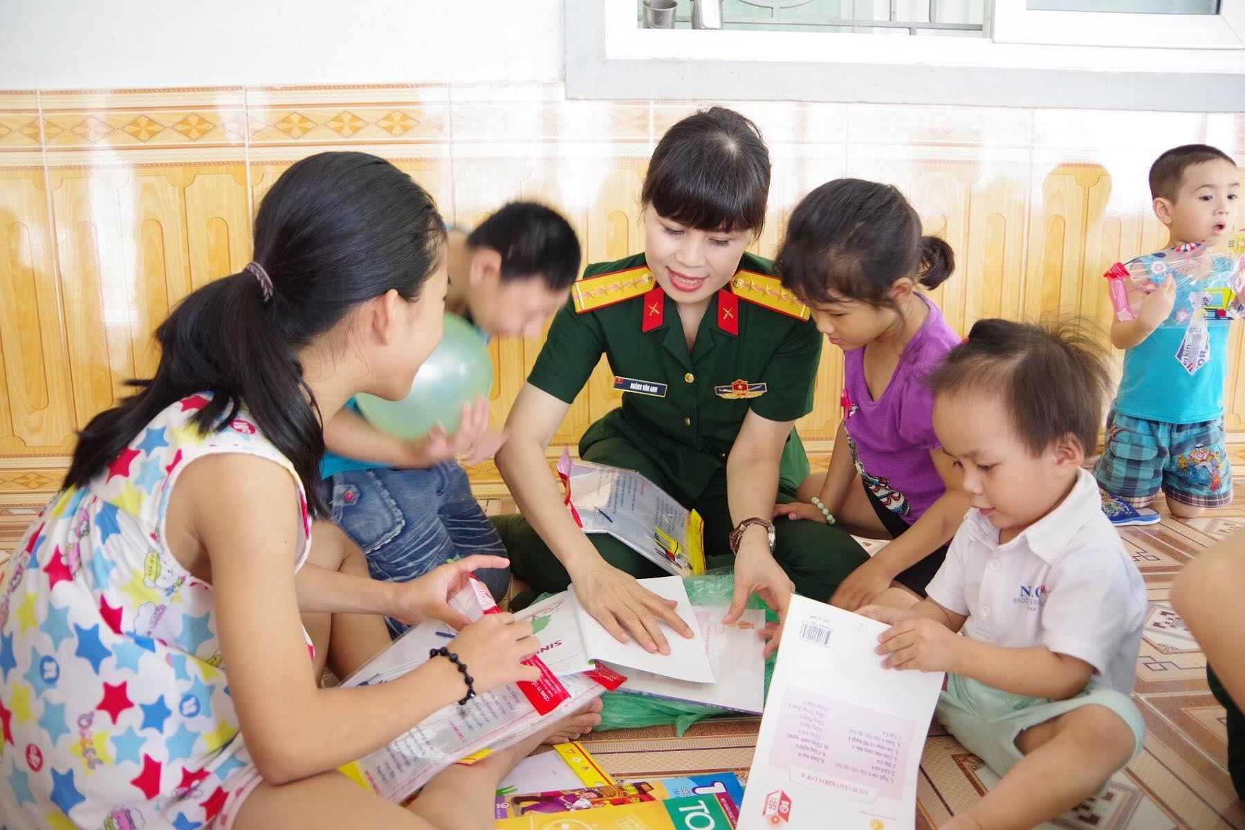 Đại úy Hoàng Vân Anh - Chủ tịch Hội Phụ nữ Bộ Chỉ huy quân sự tỉnh giúc các cháu nhỏ chuẩn bị sách vở. Ảnh Trọng Kiên