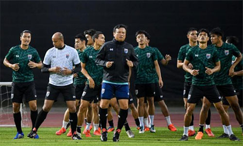 Ông Sirisak (áo khoác đen) và trợ lý Choketawee tập luyện cùng các tuyển thủ Thái Lan tại China Cup. Ảnh: Bangkok Post.