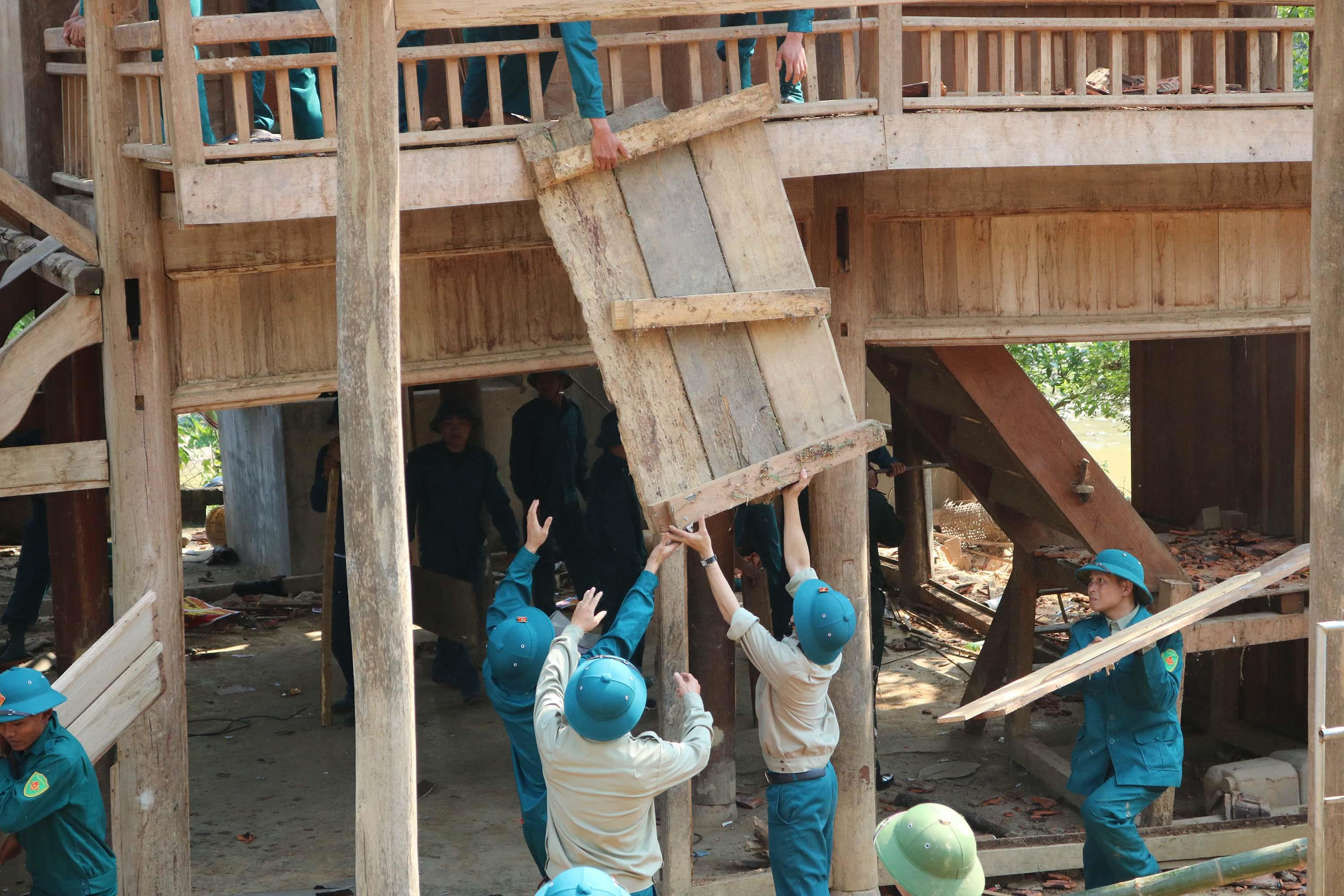 115 chiến sĩ dân quân tự vệ đã tập trung di chuyển nhiều tài sản và ngôi nhà sàn 2 tầng ra khỏi nơi có nguy cơ sạt lở đất. Ảnh: Lữ Phú