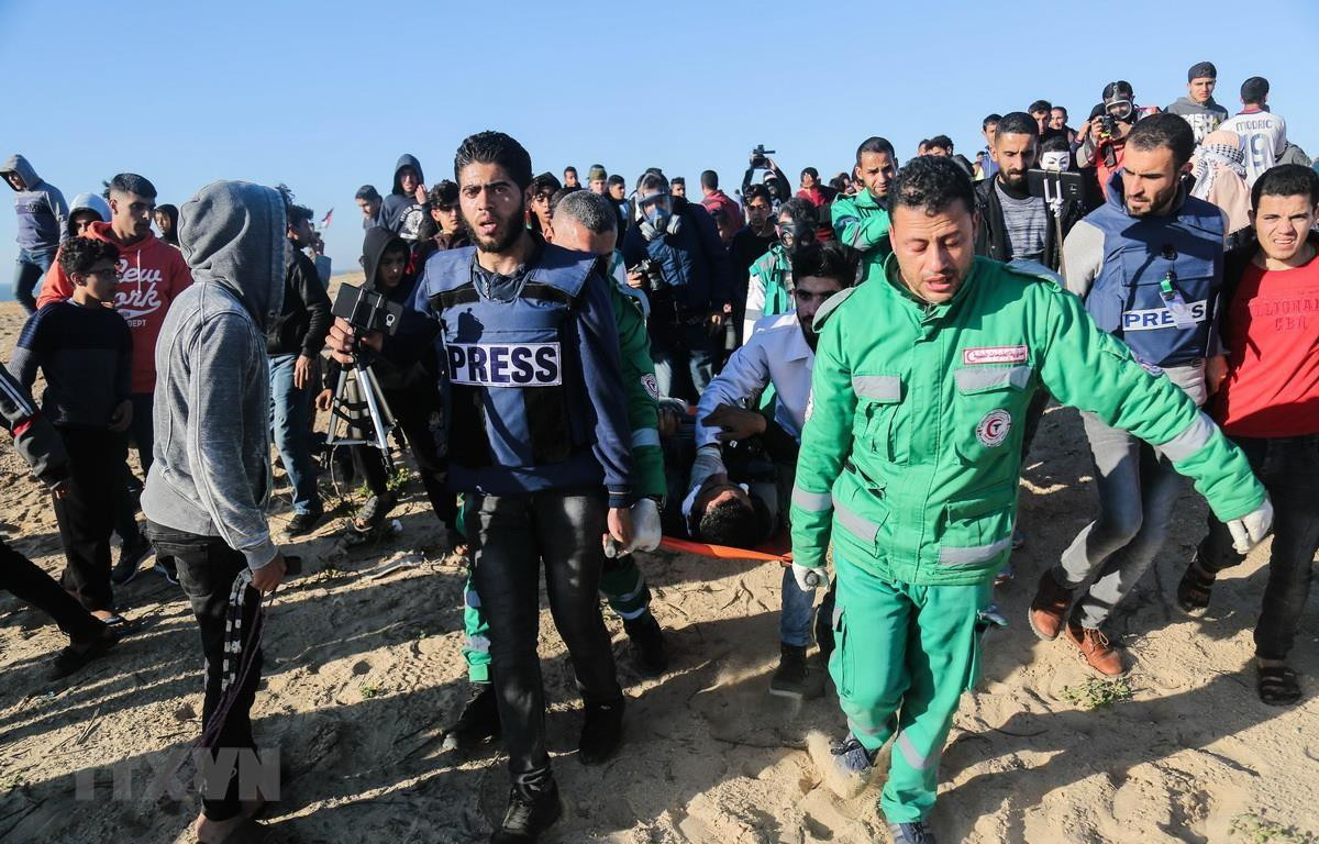 Nhân viên y tế chuyển người biểu tình Palestine bị thương tại Dải Gaza, ngày 19/3 vừa qua. Ảnh: THX/TTXVN