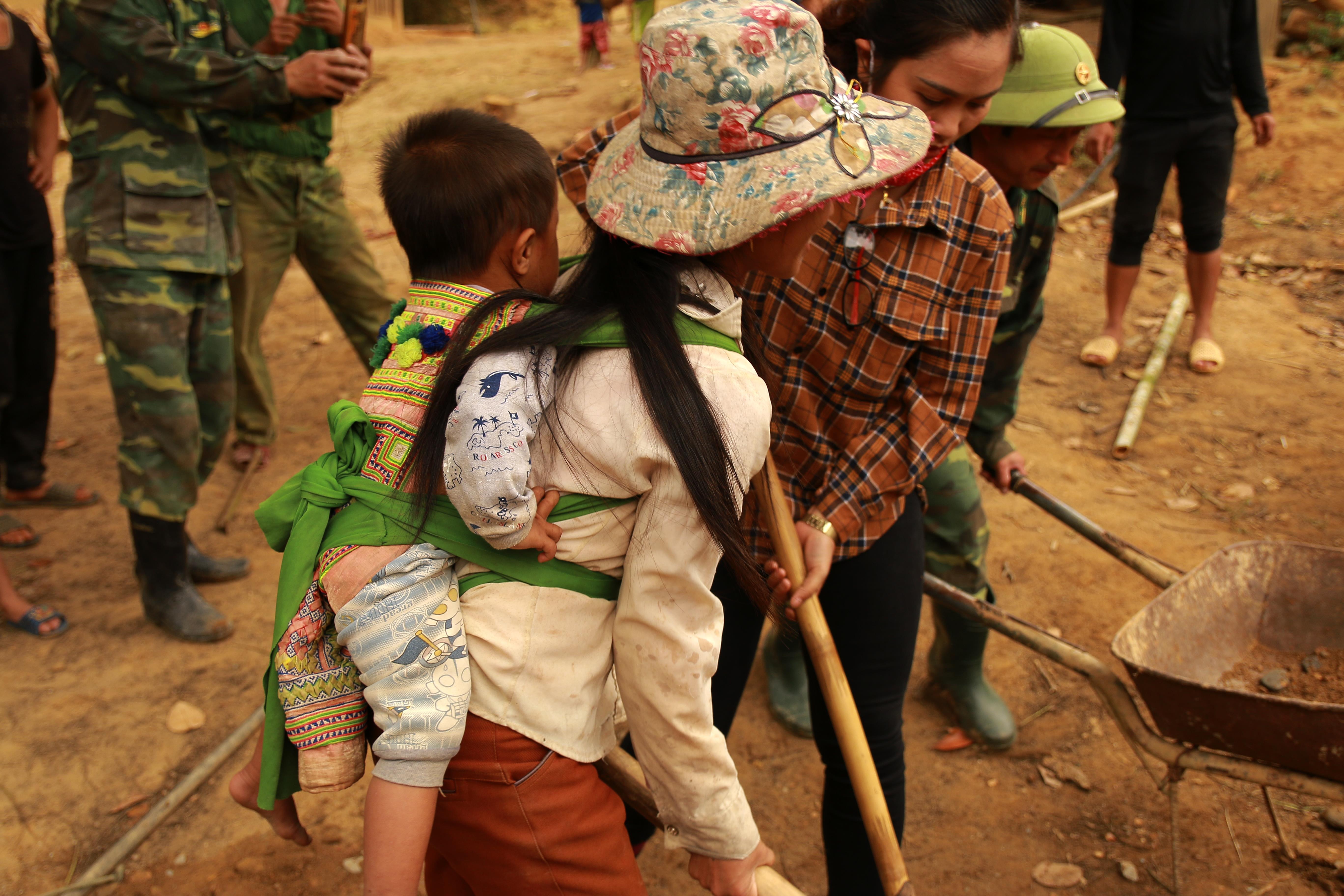 Nhiều chị vừa địu cả con nhỏ trên lưng vừa tham gia làm đường. 