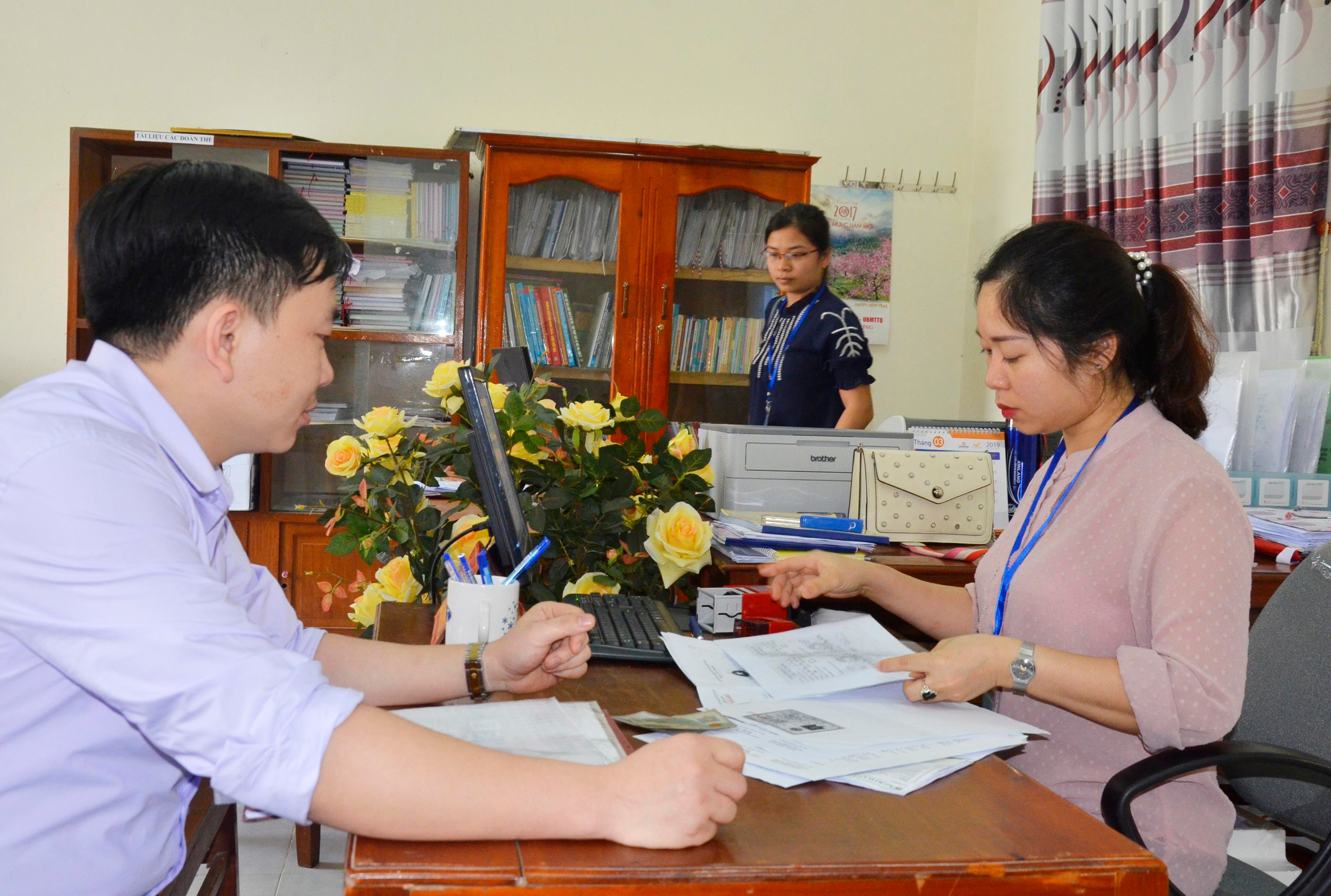 Cán bộ, công chức thị trấn Hòa Bình, Tương Dương giải quyết thủ tục hành chính cho người dân. Ảnh: Thanh Lê