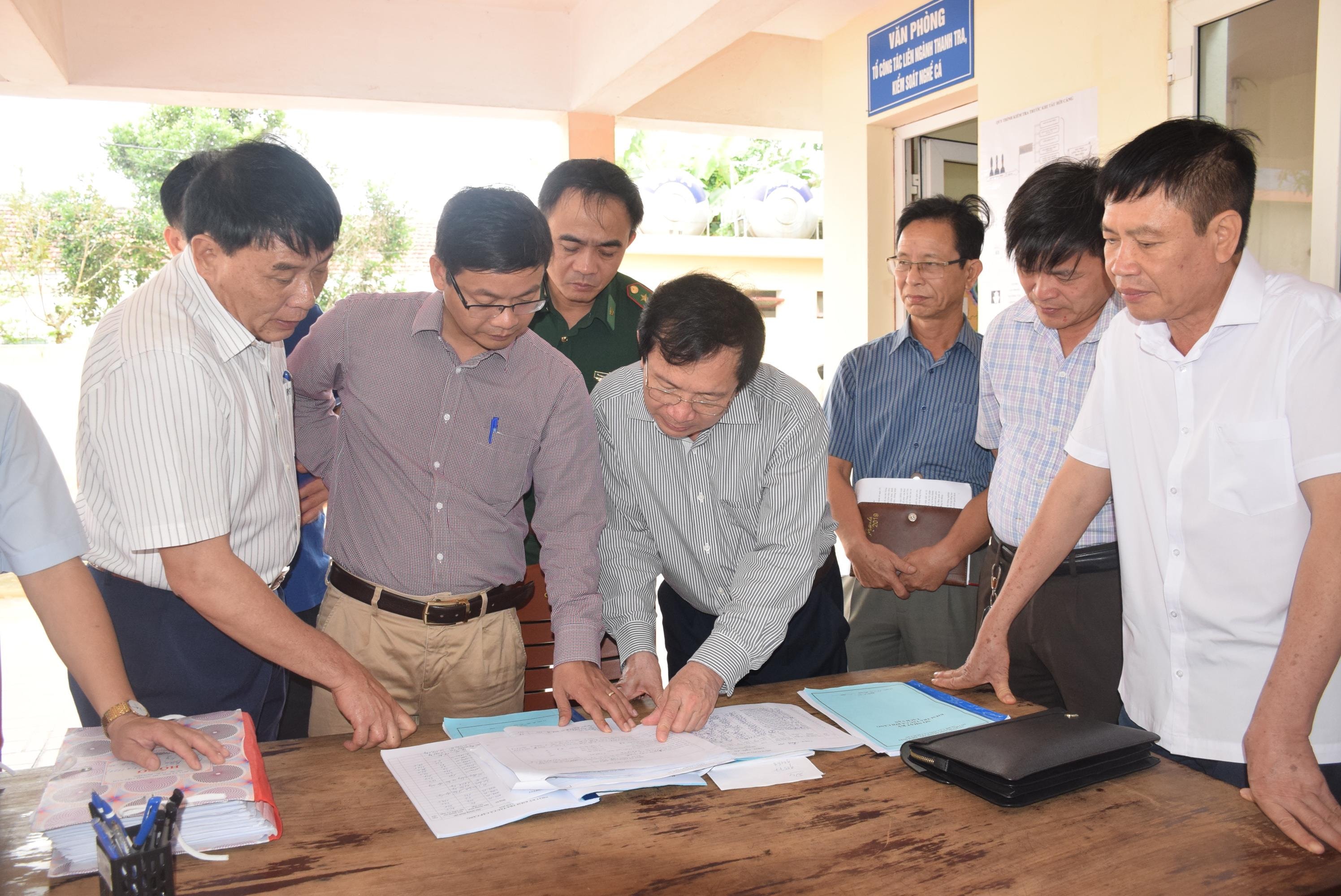 Đồng chí Đinh Viết Hồng - Phó Chủ tịch UBND tỉnh kiểm tra công tác ghi chép nhật ký tàu thuyền tại cảng cá Lạch Vạn. Ảnh: Xuân Hoàng