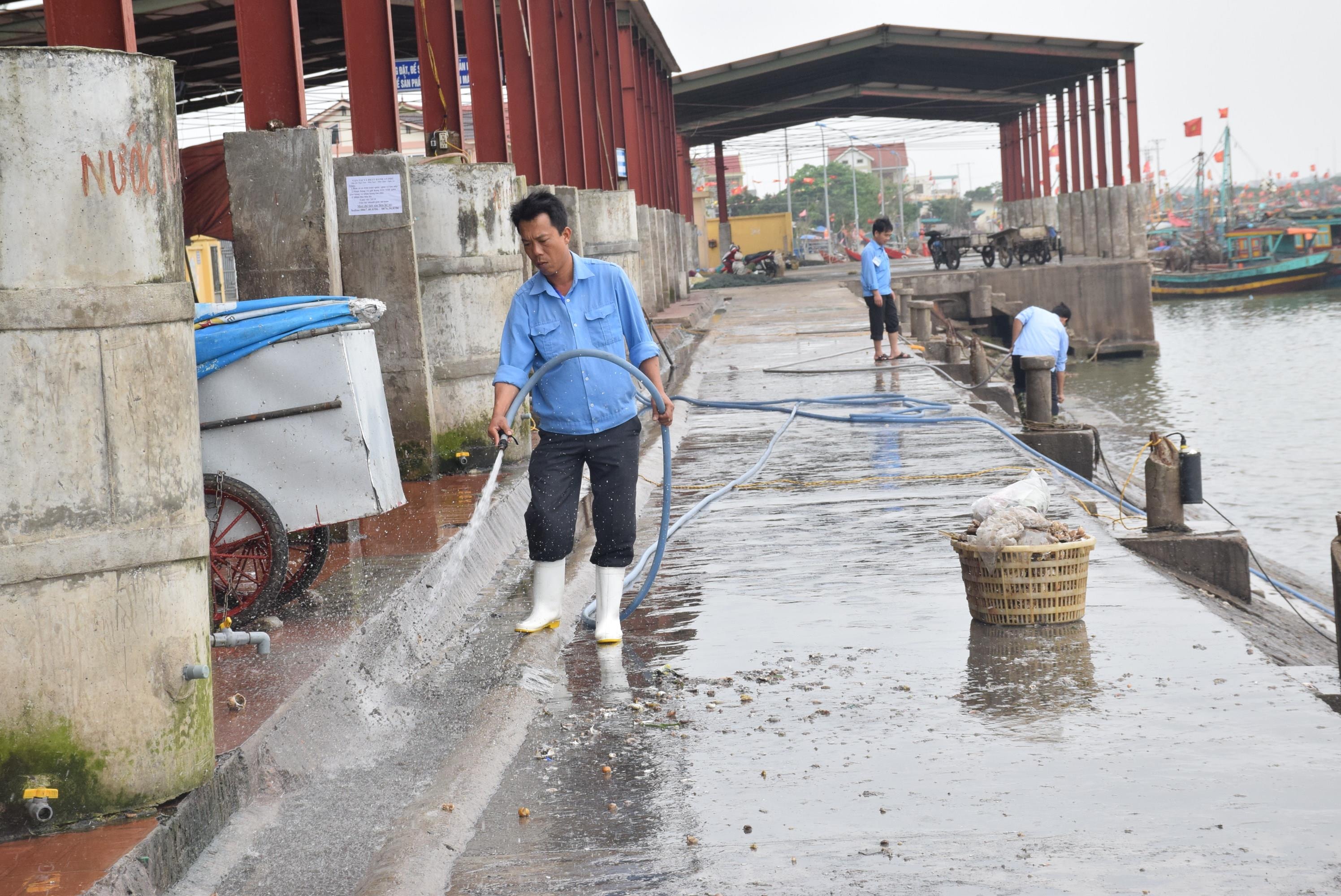 Thu dọn vệ sinh cảng cá là nhiệm vụ hàng ngày của Ban quản lý cảng cá Lạch Vạn. Ảnh: Xuân Hoàng