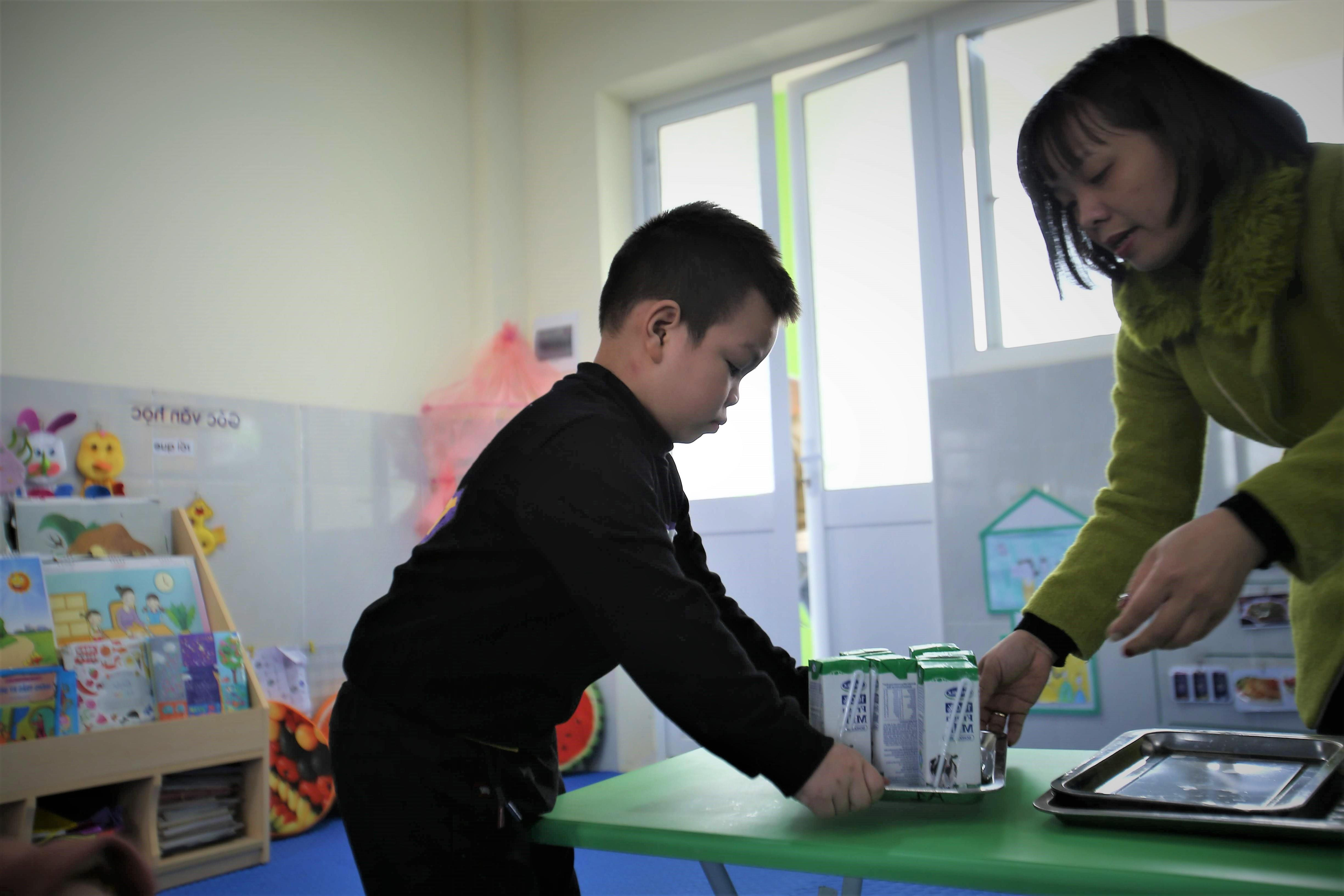 Cô giáo chuẩn bị sữa cho các bé tham gia Chương trình sữa học đường tại một điểm trường ở Hà Nội. Ảnh: PV