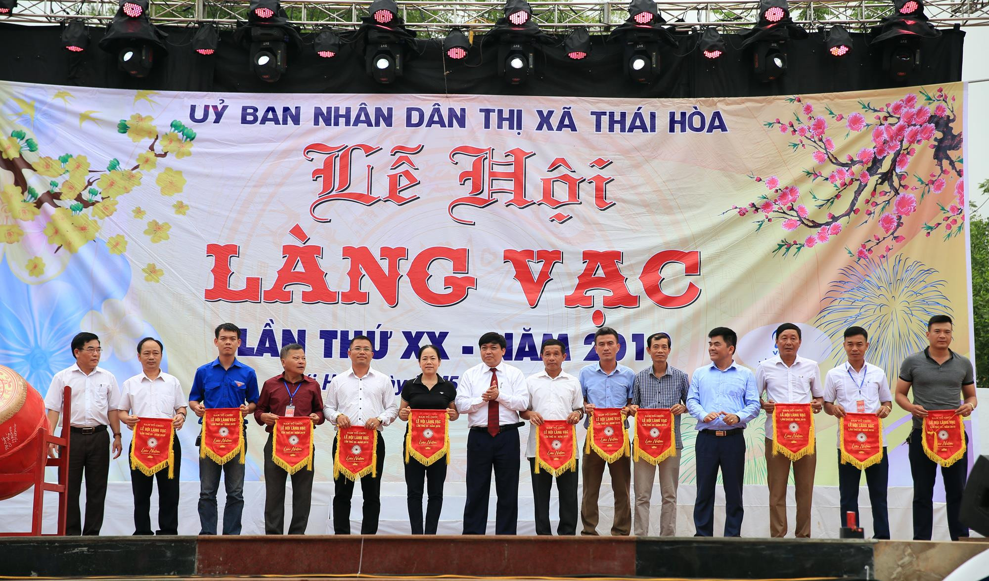 Đại diện lãnh đạo huyện trao cờ lưu niệm cho các đơn vị tham gia lễ hội Làng Vạc năm 2019.