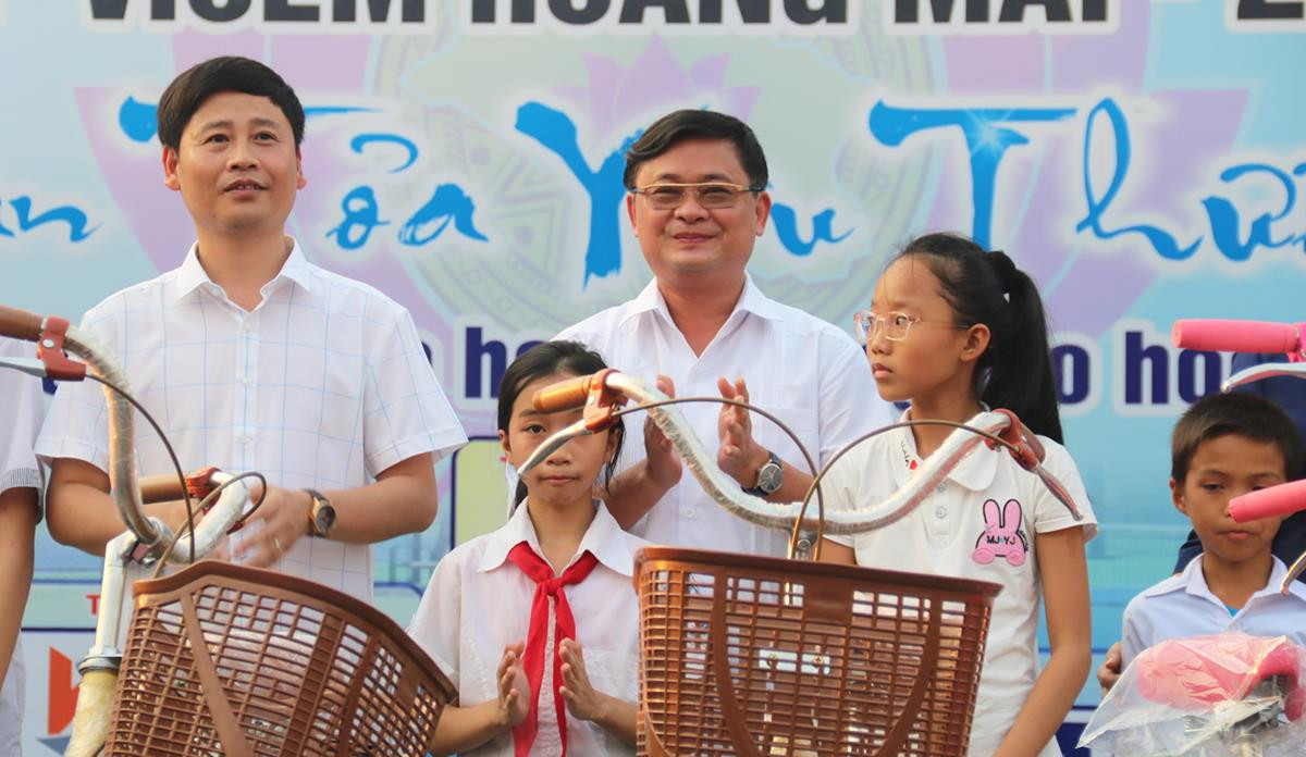 Chủ tịch UBND tỉnh Thái Thanh Quý cùng các đại biểu tặng xe đạp cho các em học sinh tại lễ khai mạc. Ảnh: Trung Kiên