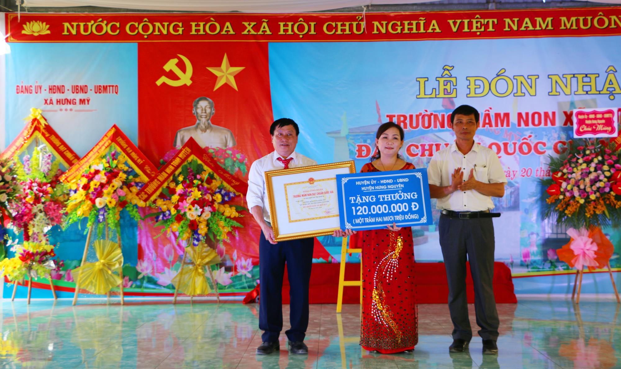 Trao Bằng công nhận đạt chuẩn Quốc gia mức 2 và phần thưởng 120 triệu đồng của huyện Hưng Nguyên cho UBND xã và Trường Mầm non Hưng Mỹ. Ảnh: Nguyễn Hải