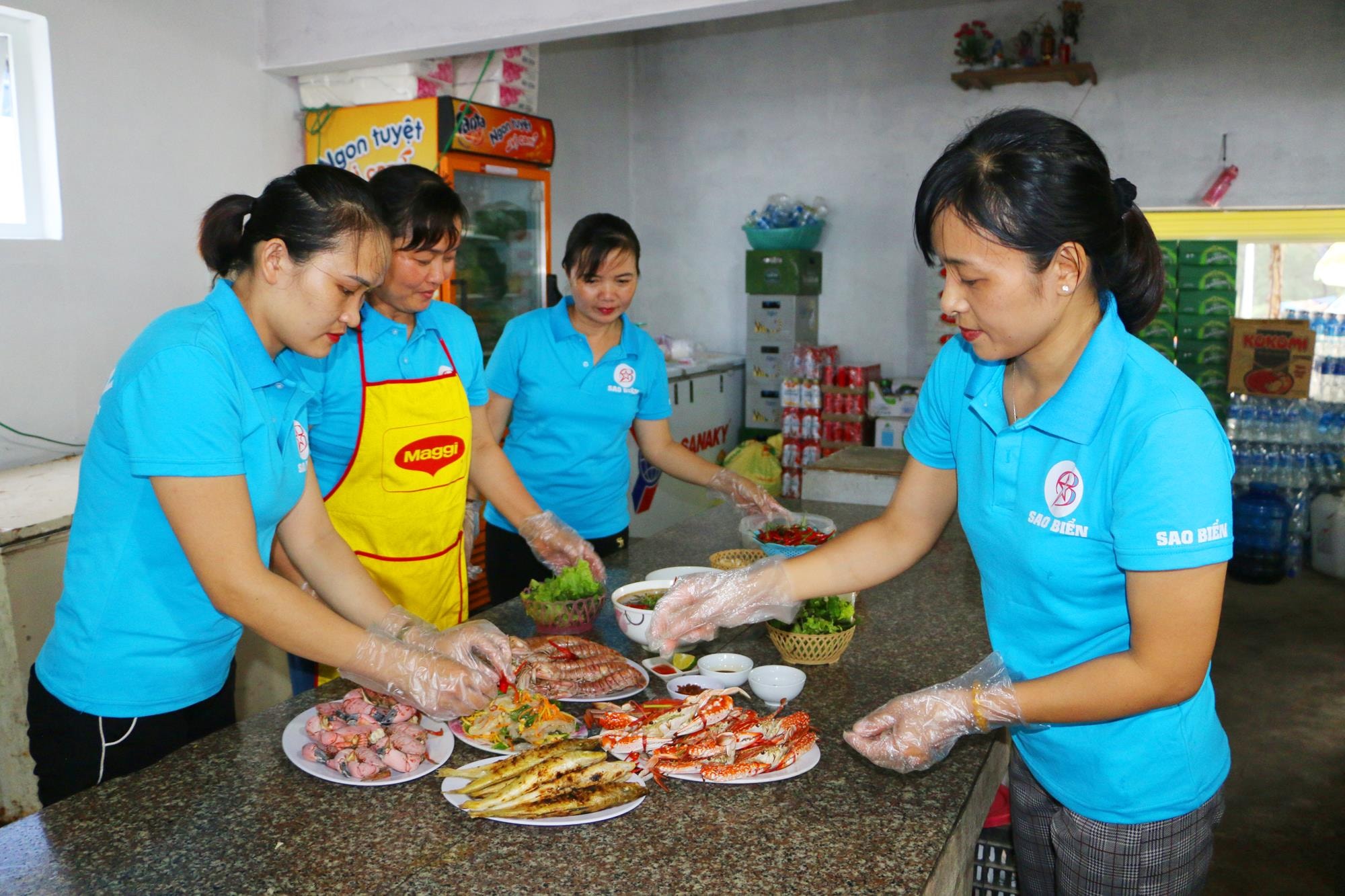 Nhân viên nhà hàng soạn món cho khách, trong đó món đặc sản là Rum, mực hấp, tôm tít, Cua đá