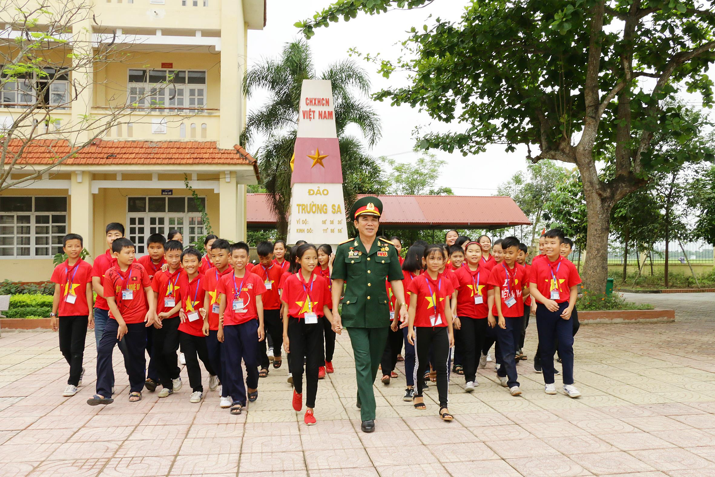 Đại tá Nguyễn Huy Hướng trò chuyện về những câu chuyện kỷ niệm Chiến thắng 30/4 với học sinh Trường THCS Kim Liên (Nam Đàn). Ảnh: Mỹ Hà
