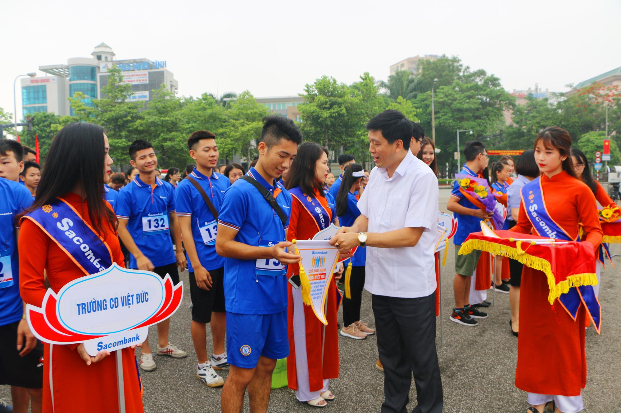 Đồng chí Kha Văn Tám, Phó Ban Tuyên giáo Tỉnh ủy tặng hoa và Cờ lưu niệm cho các đội tham gia giải Việt dã. Ảnh: Nguyễn Hải