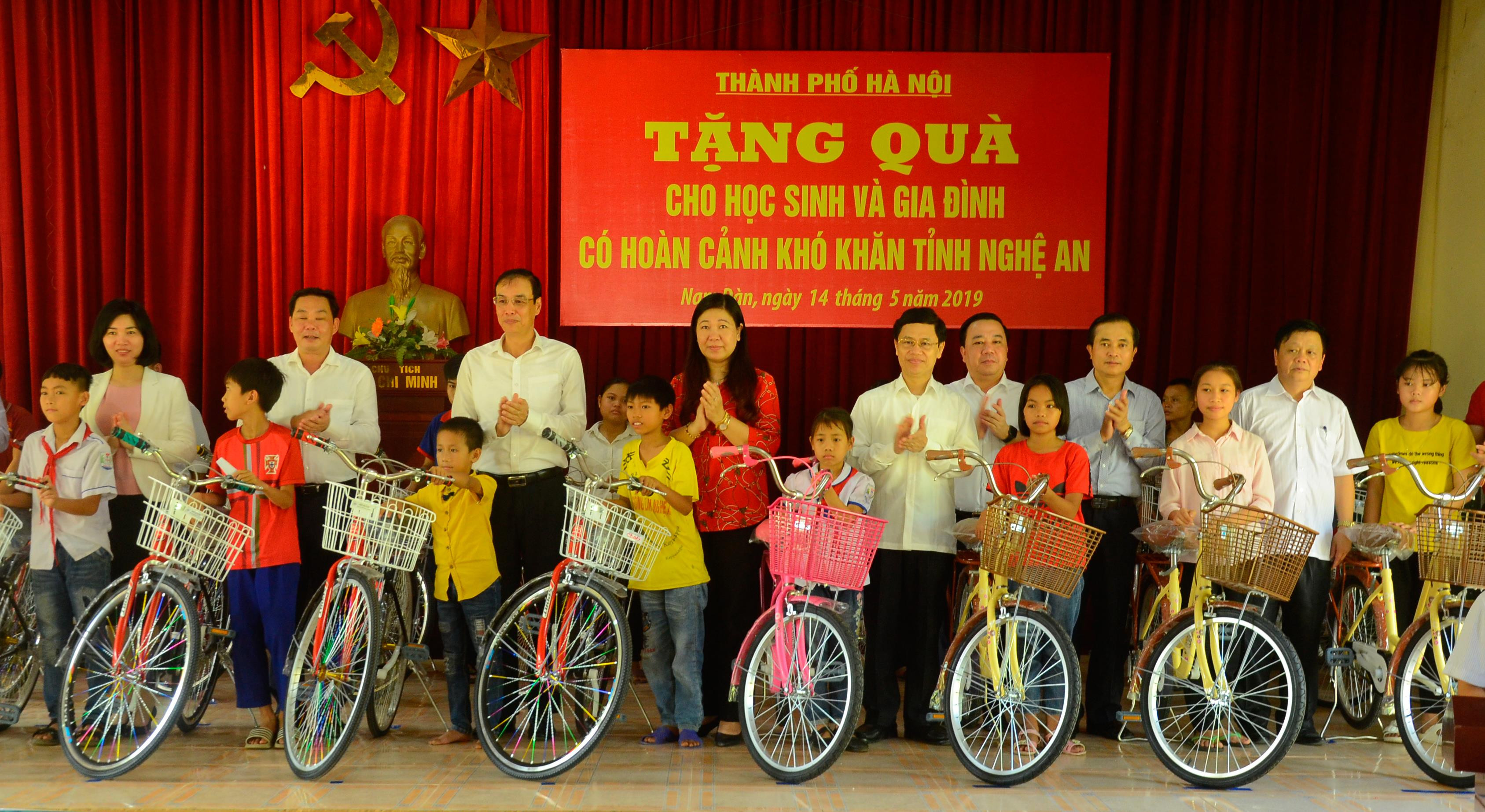 Các đồng chí lãnh đạo thành phố Hà Nội và tỉnh Nghệ An trao tặng xe đạp cho học sinh xã Hùng Tiến (Nam Đàn). Ảnh: Thanh Lê