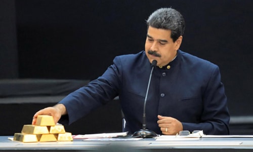 Tổng thống Venezuela Nicolas Maduro đặt những thỏi vàng lên bàn trong cuộc họp tại thủ đô Caracas hôm 22/3. Ảnh: Reuters.