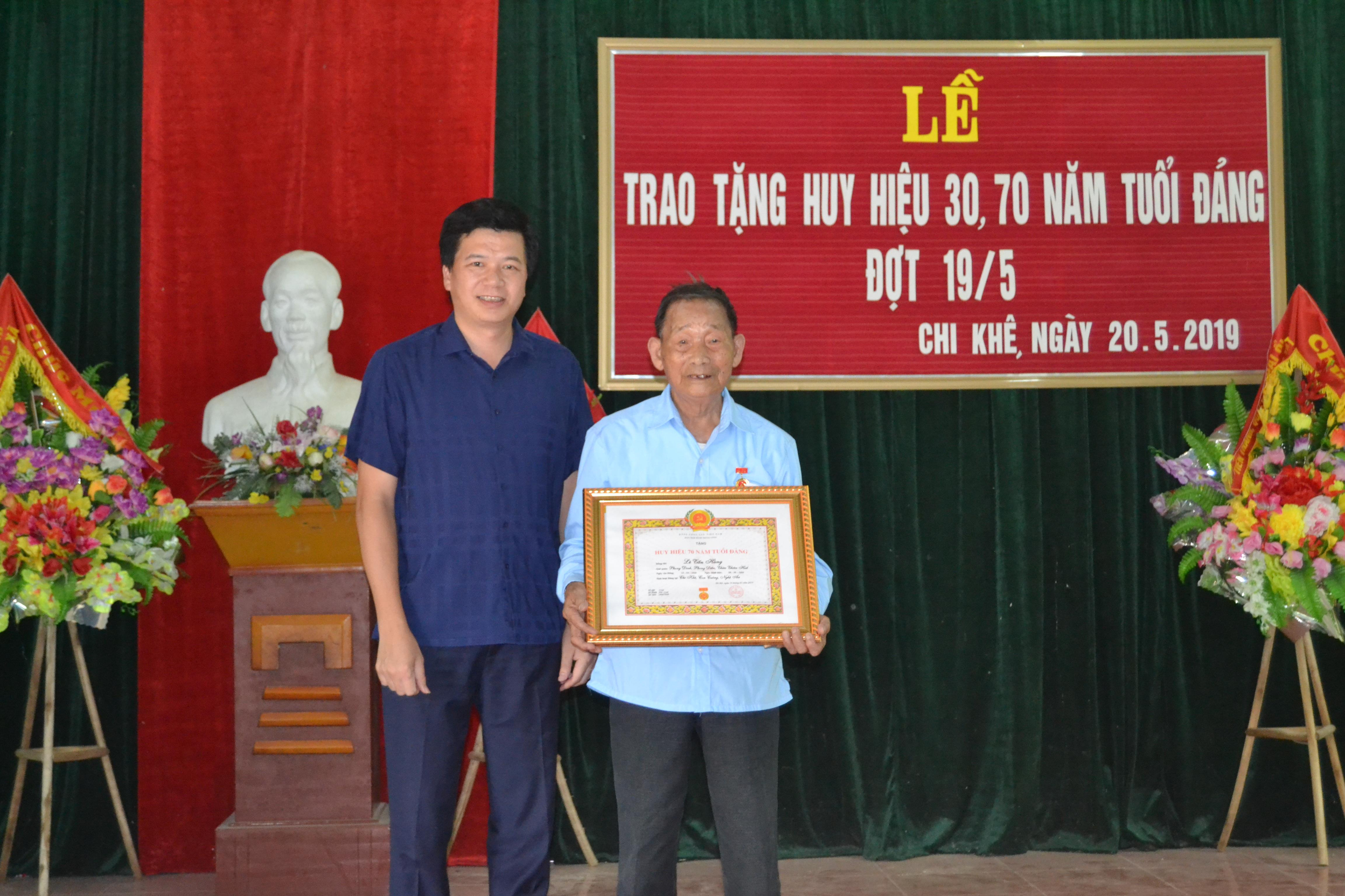 Bí thư Huyện ủy Con Cuông Nguyễn Đình Hùng trao Huy hiệu 70 năm tuổi Đảng cho đảng viên Lê Tấn Hùng. Ảnh: Bá Hậu 