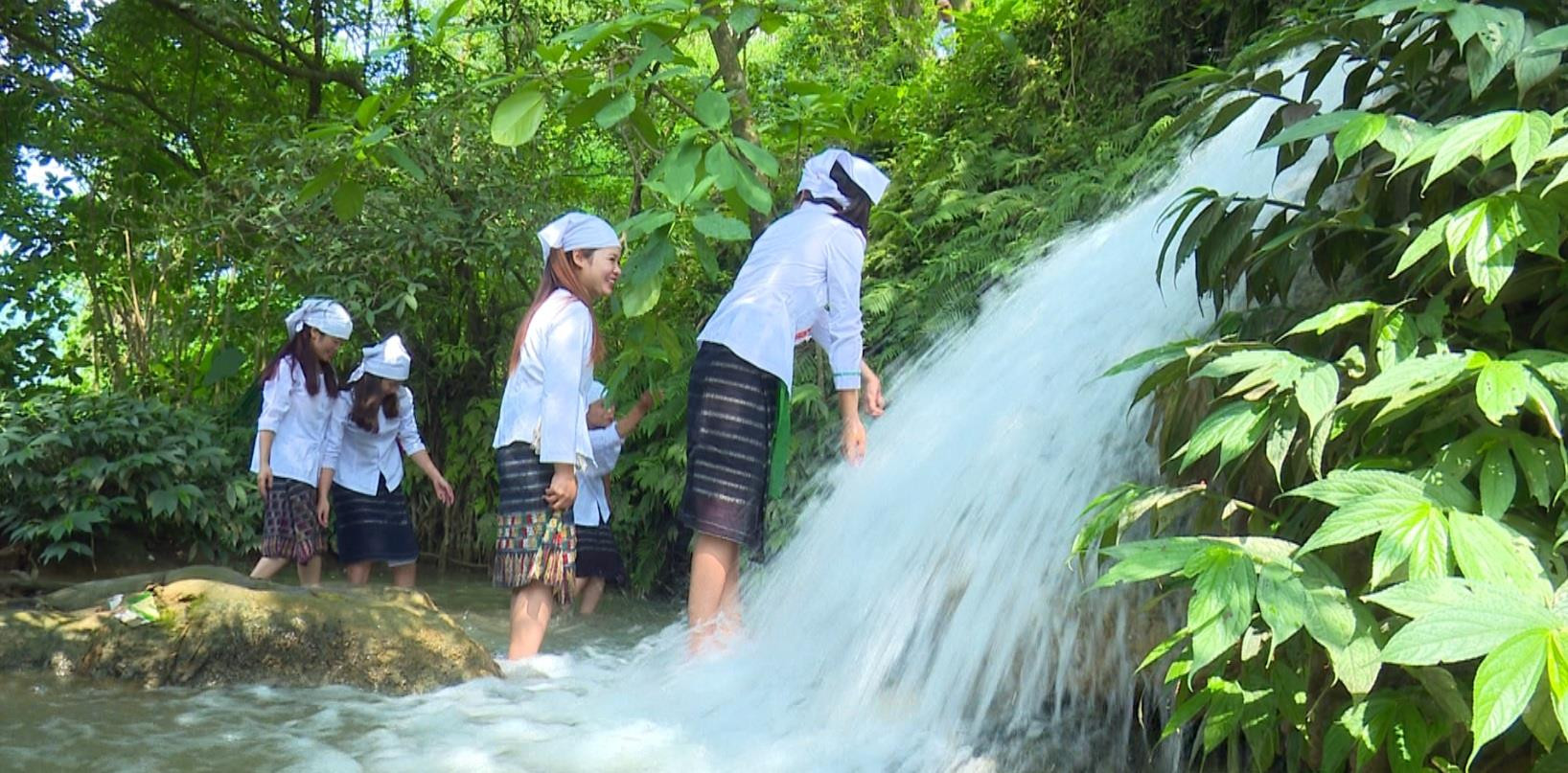 Các cô gái dân tộc Thổ ở Tân Hợp vui đùa bên thác kè Hồng Sơn. Ảnh: Cẩm Tú