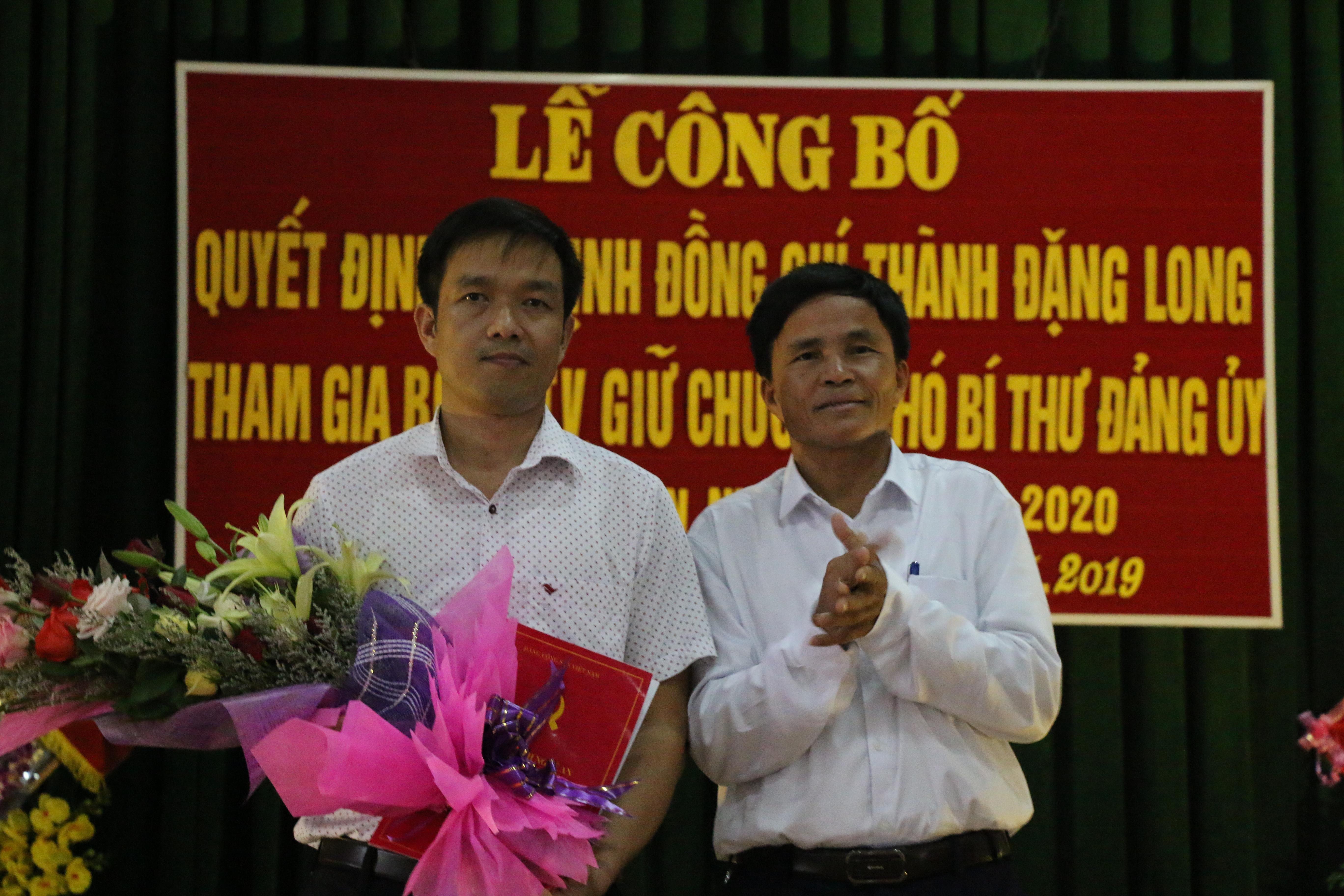 Đồng chí Lê Minh Giang - Phó Bí thư Thường trực Huyện ủy, Chủ tịch HĐND huyện Đô Lương trao quyết định và tặng hoa chúc mừng đồng chí Thành Đặng Long. Ảnh: Hữu Hoàn