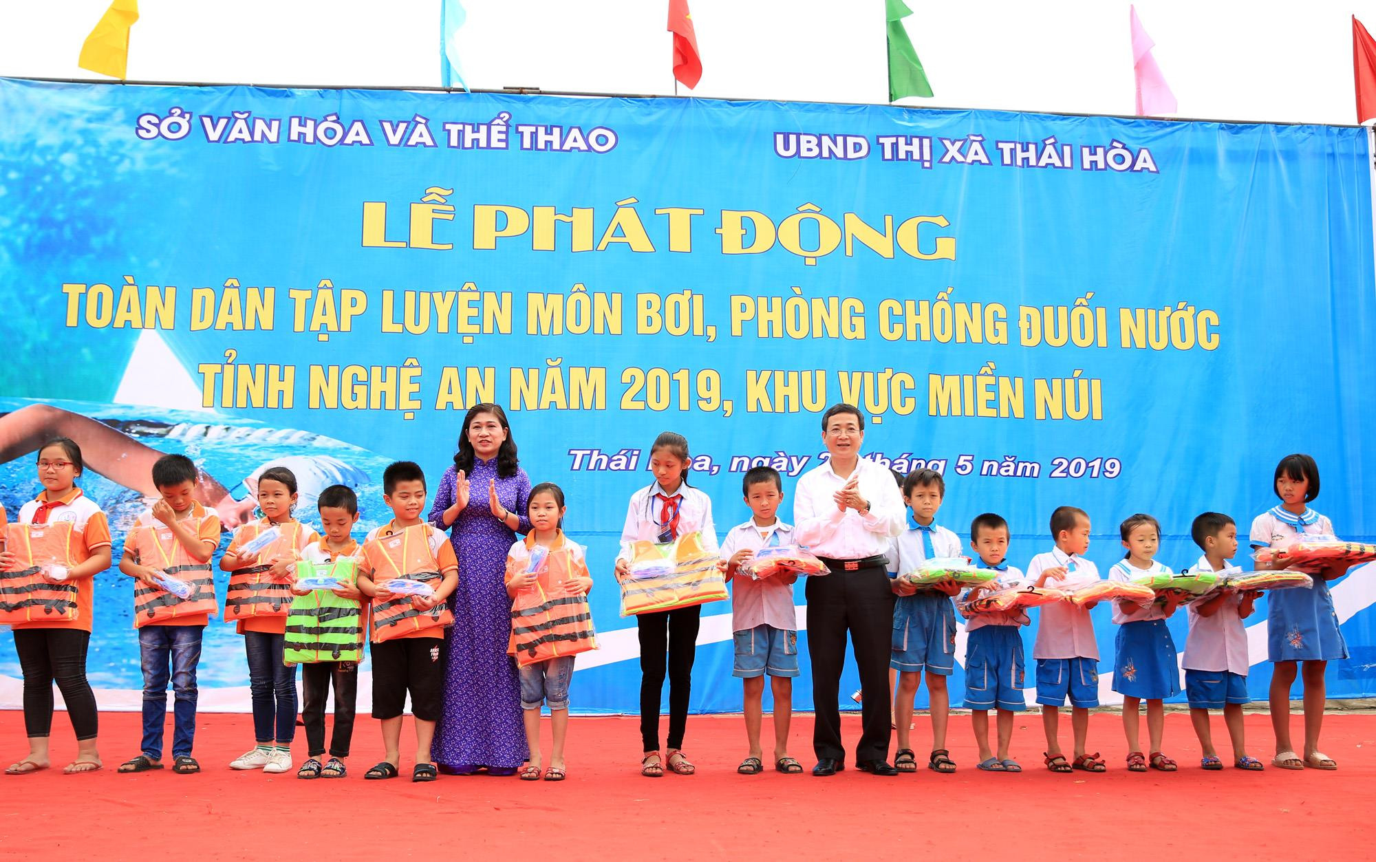 Đại diện ban tổ chức trao áo phao cho các em học sinh nghèo trên địa bàn thị xã Thái Hòa. 